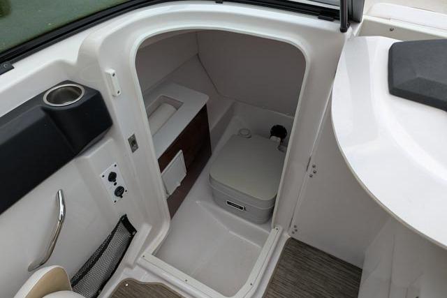 2017 Scarab 255 Platinum SE boat interior with compact marine toilet and storage.