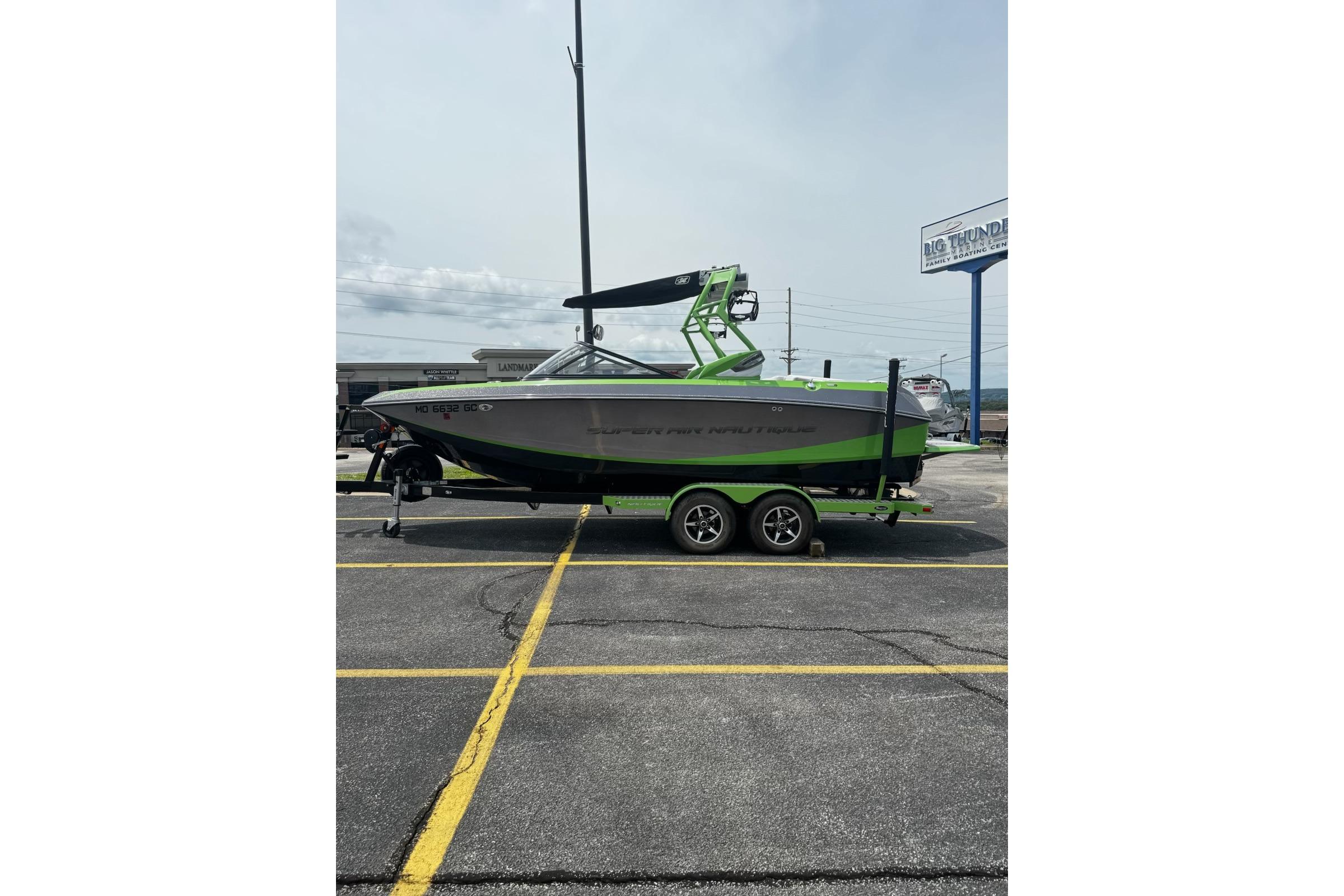 2014 Nautique Super Air Nautique G21 boat on trailer in parking lot.