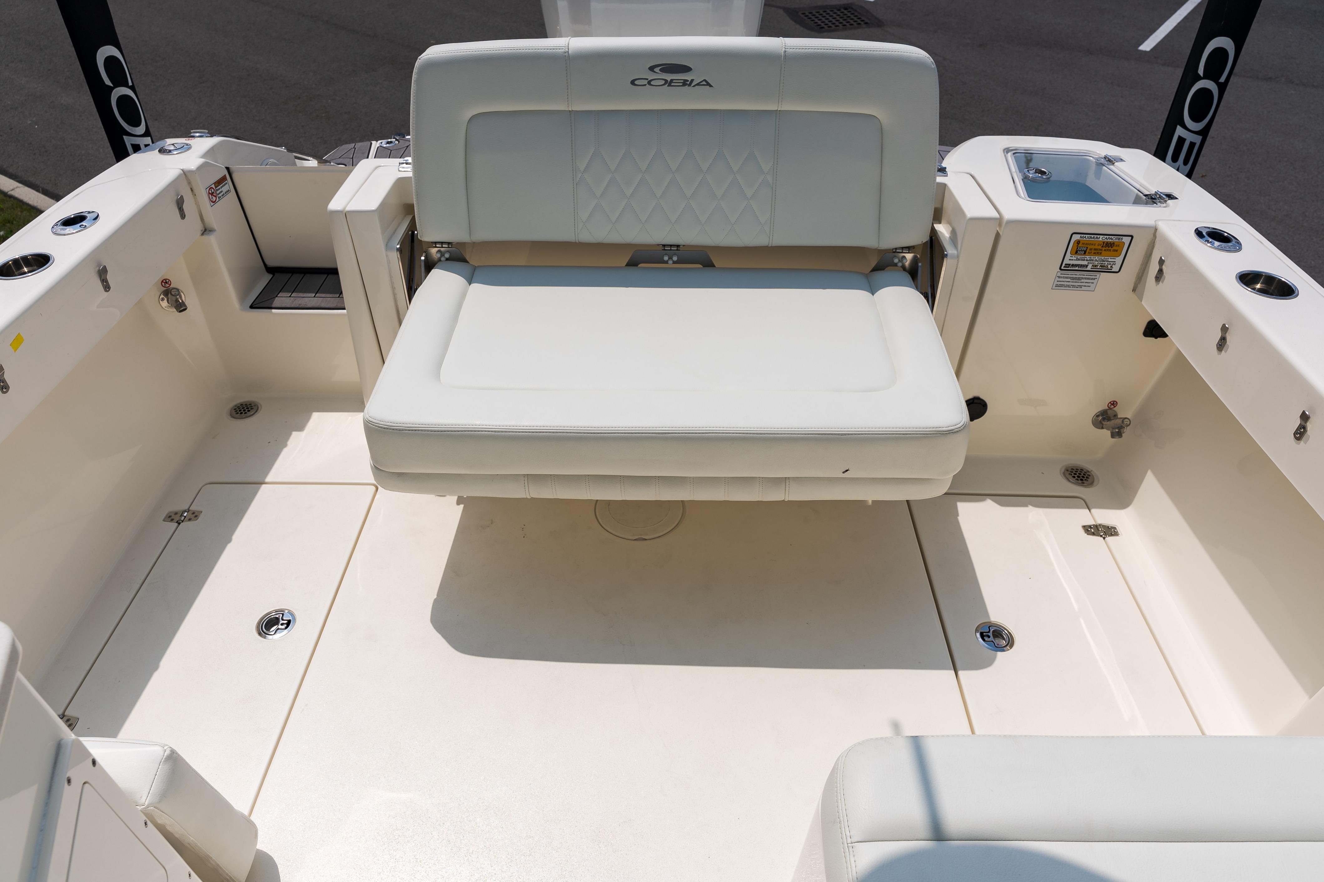 2023 Cobia 240 Dual Console boat interior with cushioned seating and storage compartments.