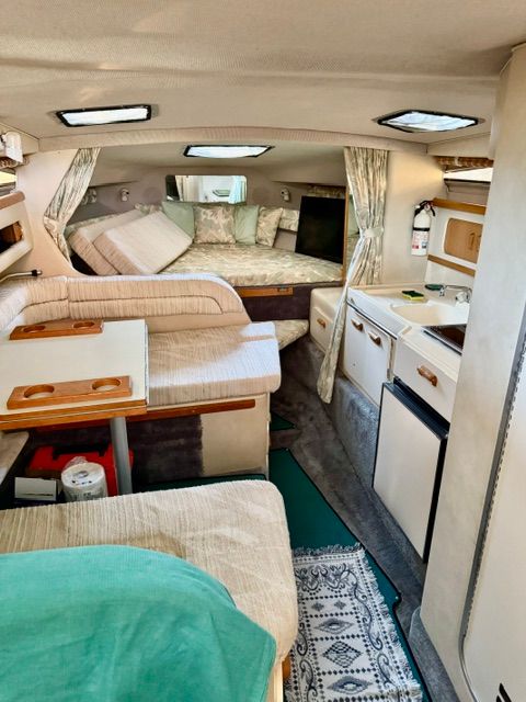 Interior of the 1992 Sea Ray 290 Sundancer with cozy seating and a small kitchen area.