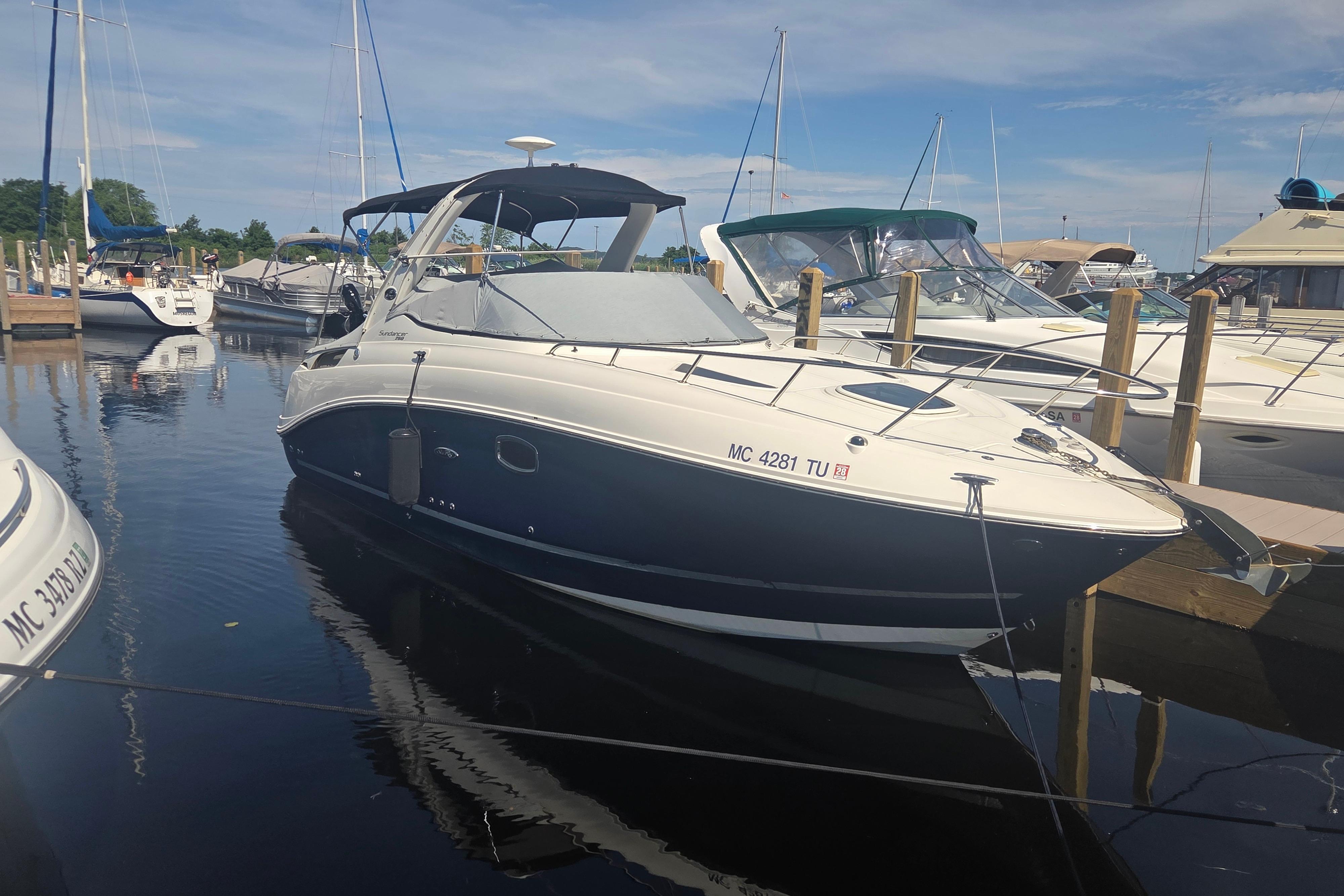 2012 Sea Ray Sundancer 260 docked at a marina under a clear blue sky.
