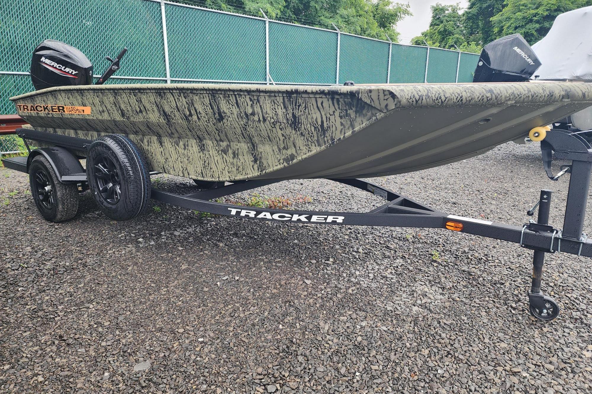 2026 Tracker Grizzly 1756 T Marsh boat on trailer, camo design, parked outdoors.