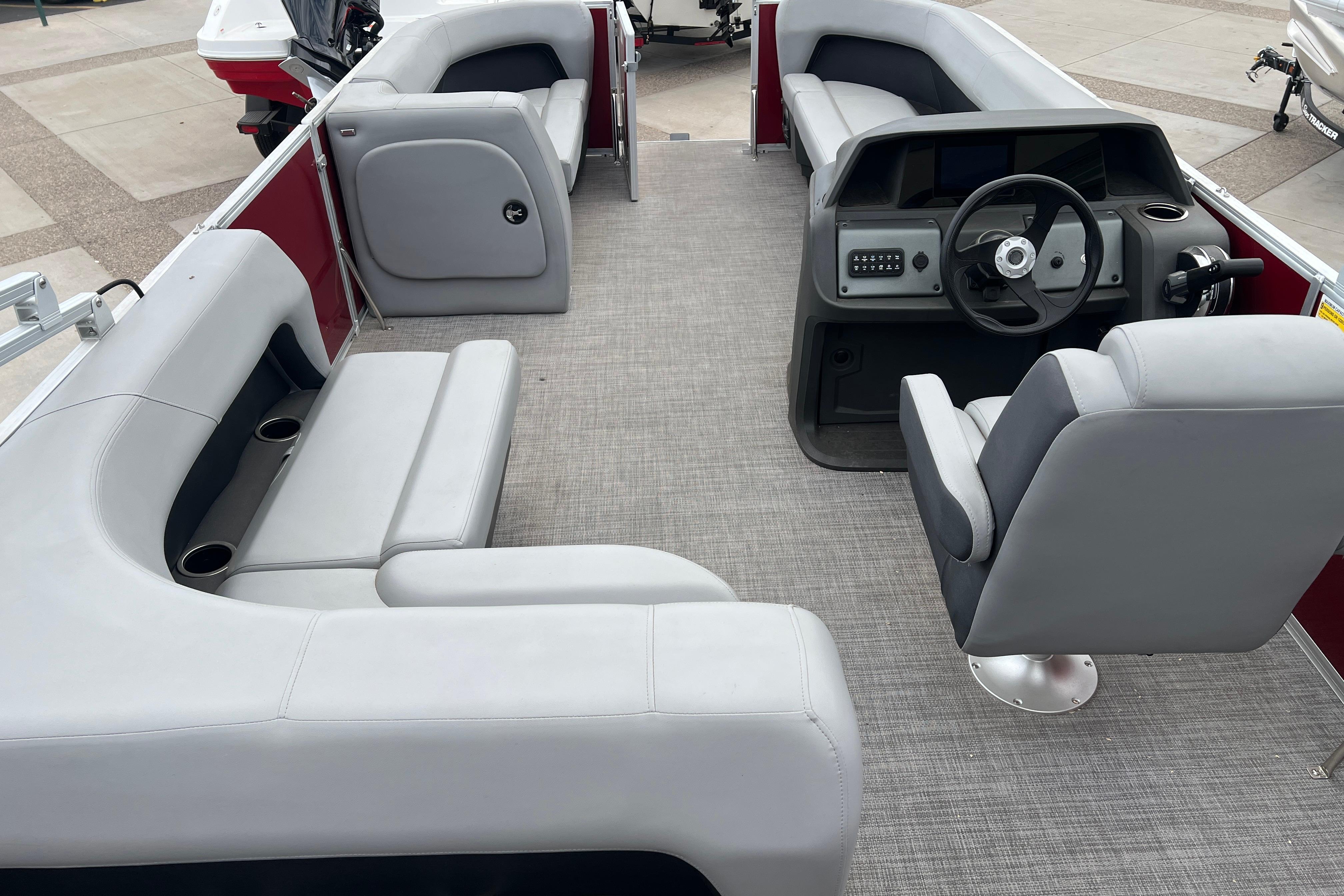 2026 Sun Tracker Party Barge 18 DLX interior with gray seating and steering console.