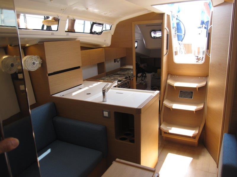 Interior of 2025 Jeanneau Sun Odyssey 350 sailboat, featuring modern kitchen and seating area.