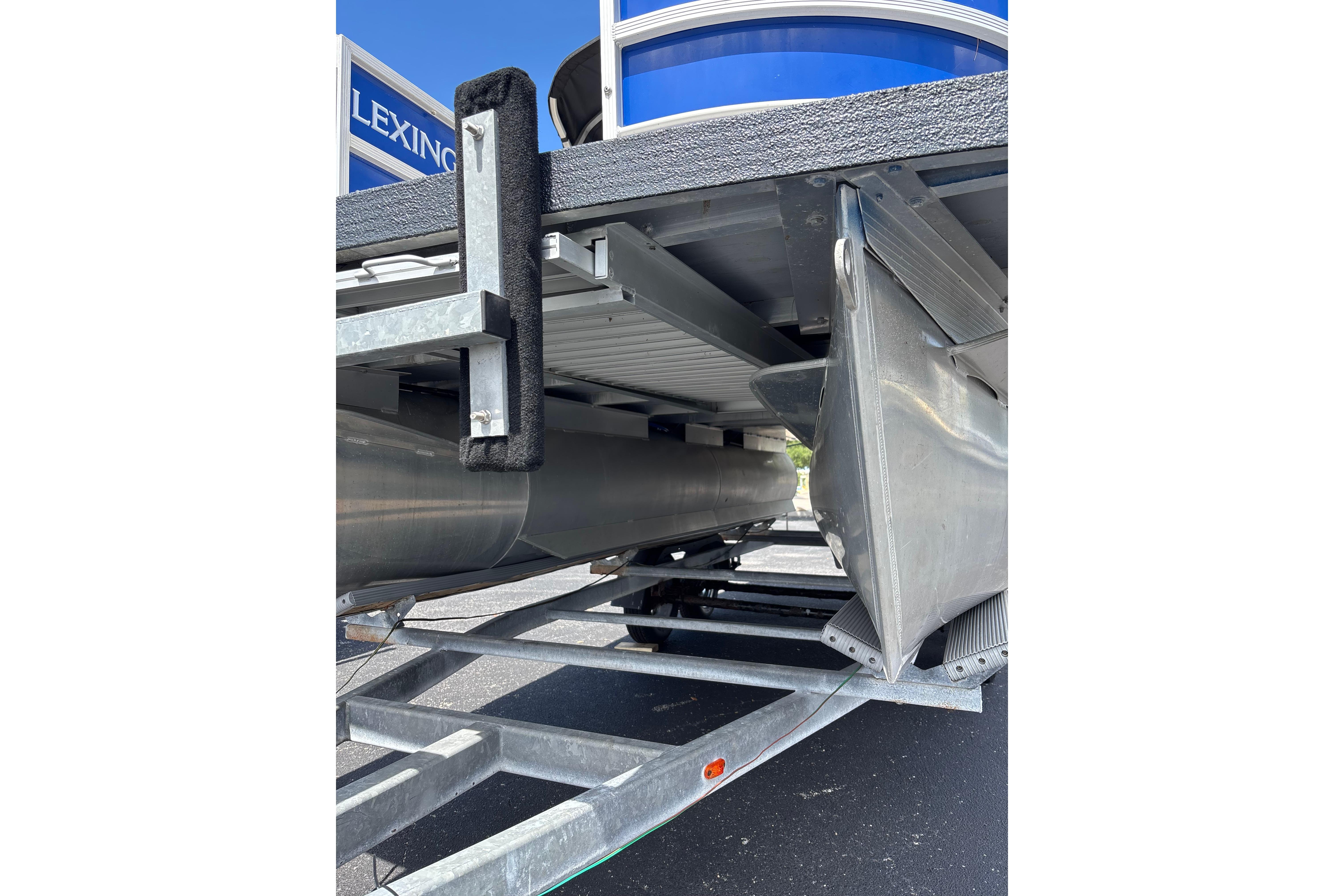 Underneath view of a 2022 Lexington 323 pontoon boat on a trailer.