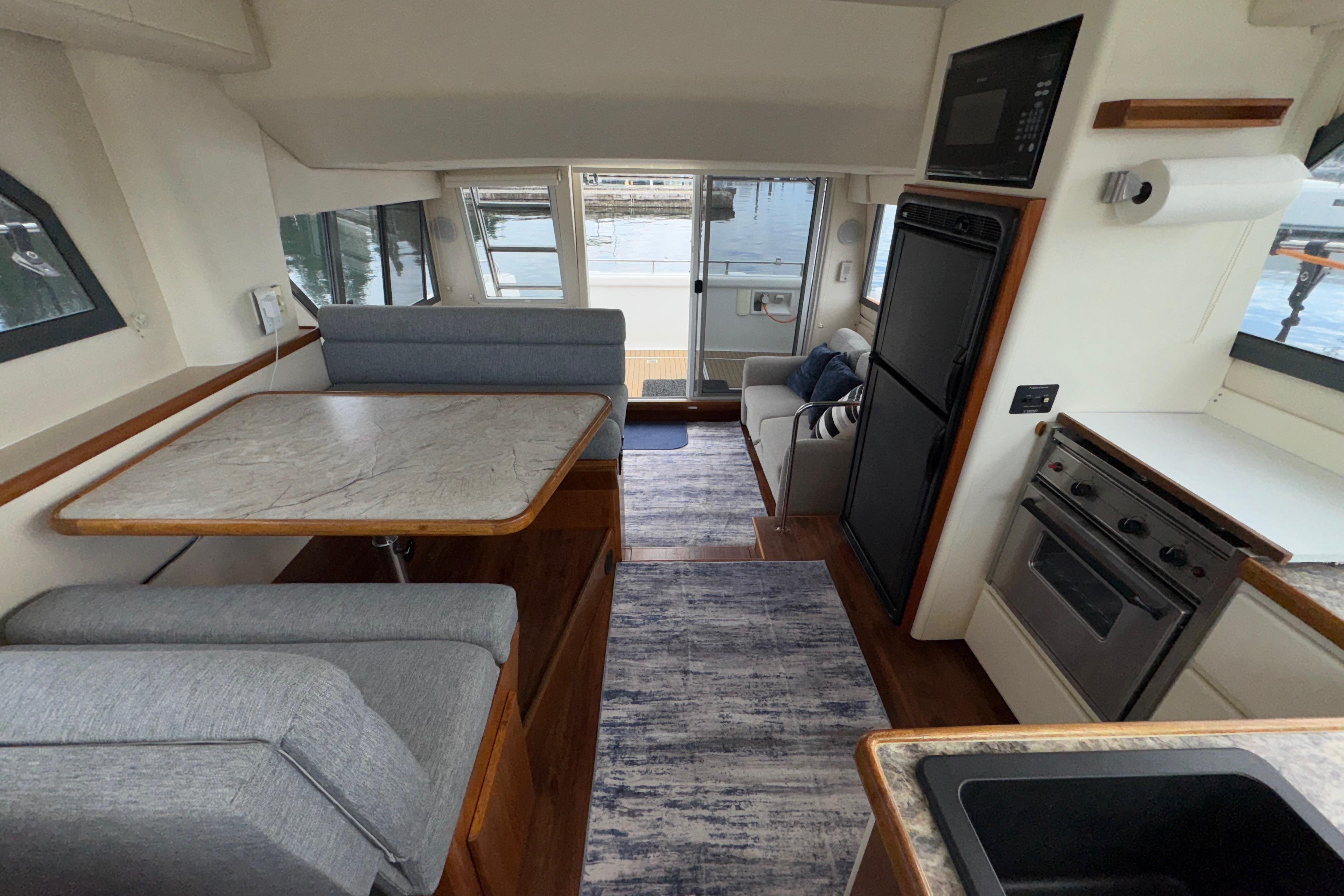 Interior of 1996 Carver 370 Voyager yacht with dining area, kitchen, and seating.