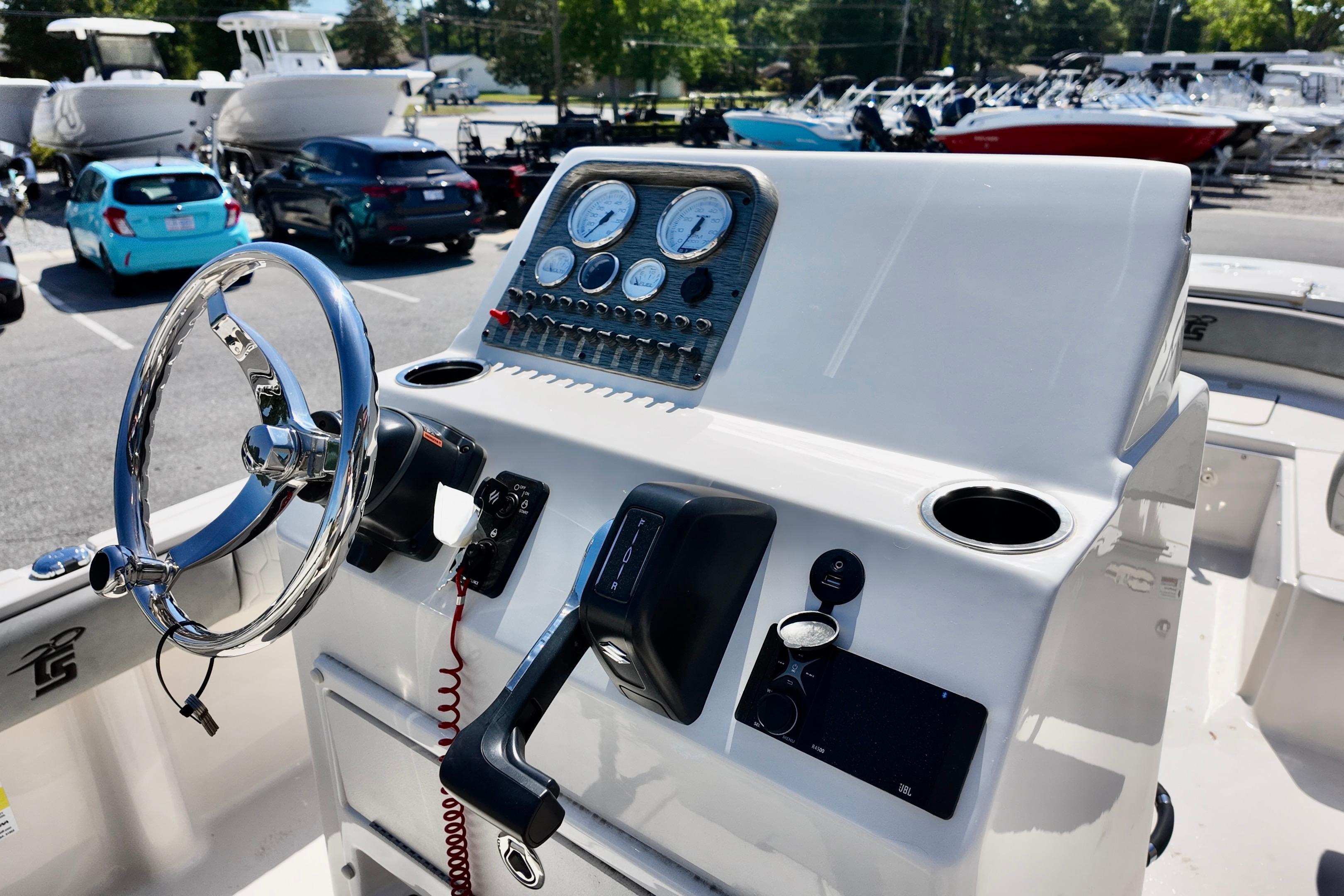 Steering console of 2026 Carolina Skiff 21 Ultra Elite boat in a marina setting.