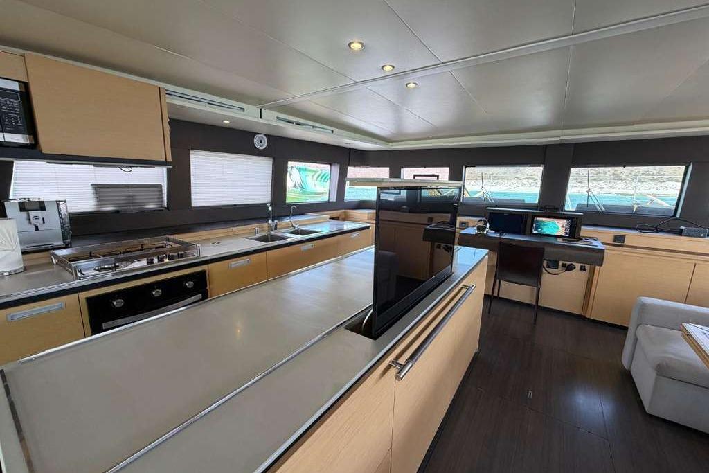Luxurious interior of 2019 Lagoon 630 MY yacht with modern kitchen and navigation area.