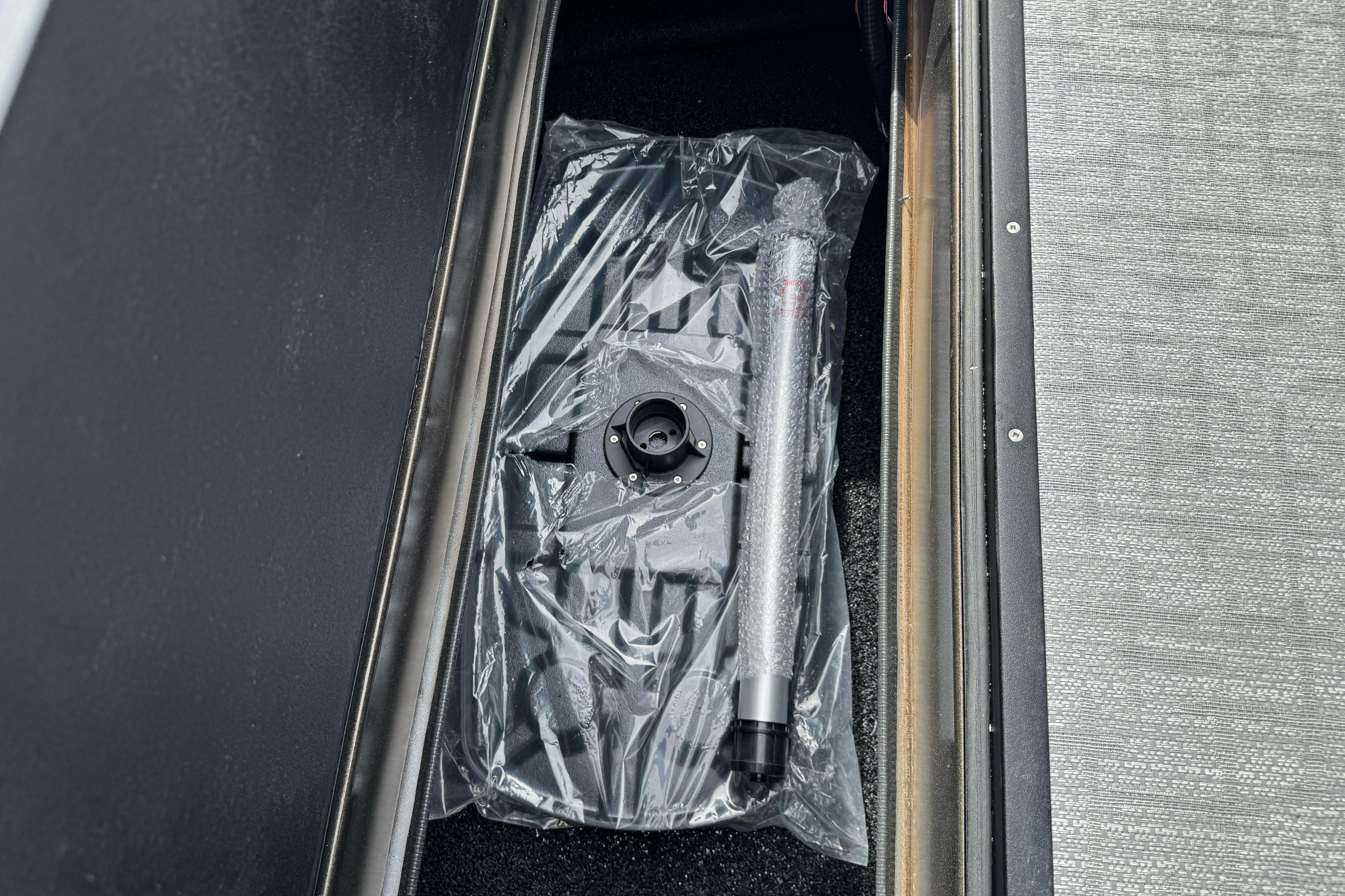 Storage compartment in 2026 Regency 250 DL boat with packaged accessories.
