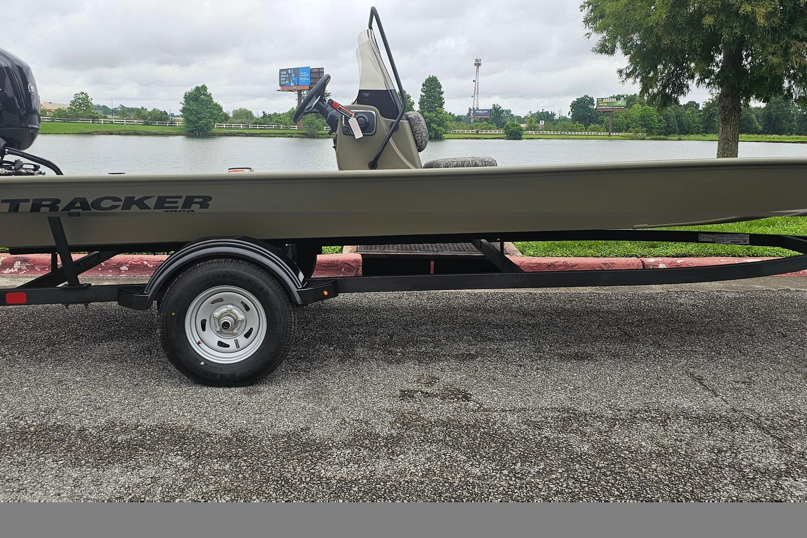 2026 Tracker Grizzly 1860 CC boat on trailer by a lake.