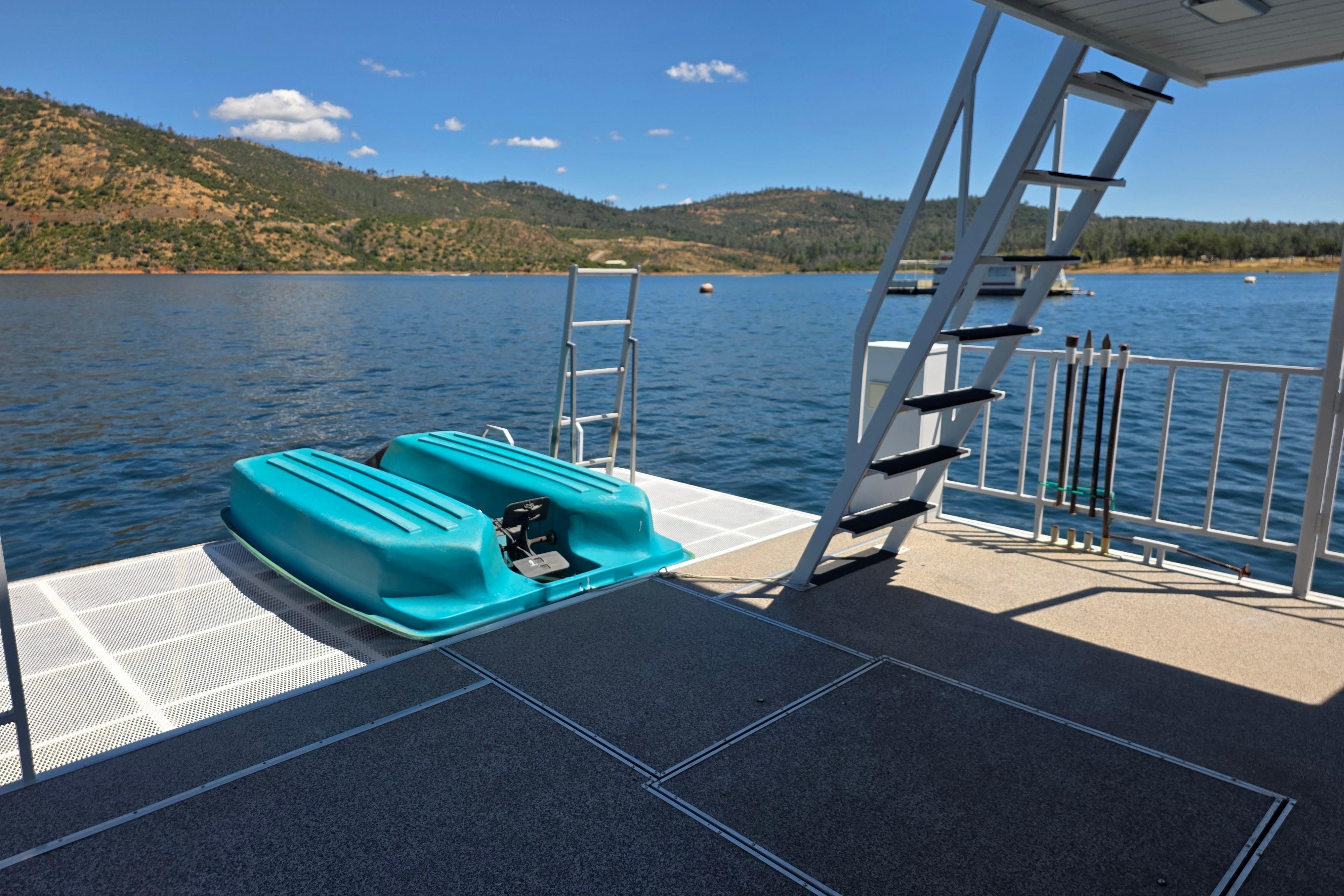 Houseboat deck with turquoise pedal boat, scenic lake view, and stairs, 2007 Custom model.