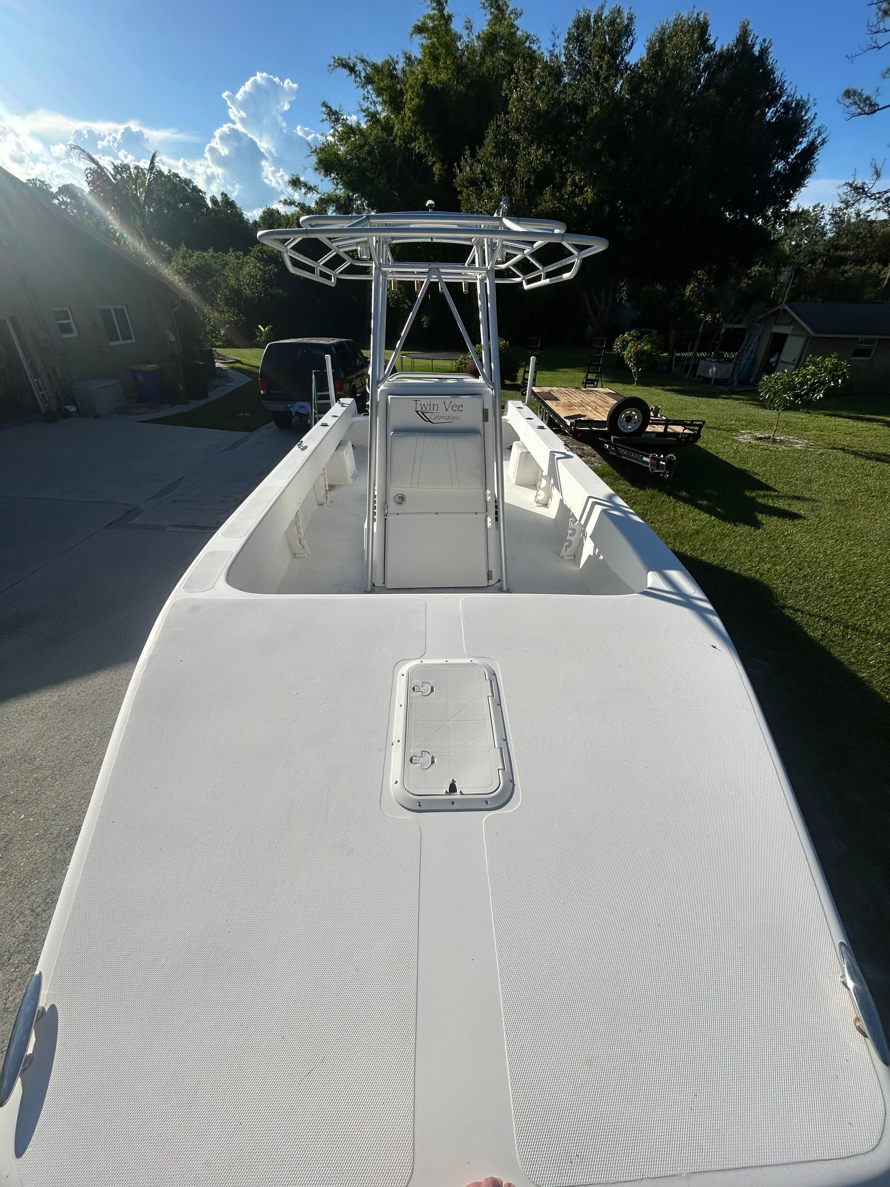 A 2007 Twin Vee 26 Center Console boat on a trailer in a yard.