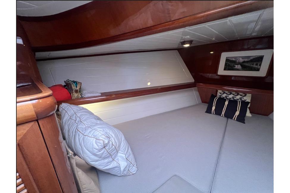 Cozy cabin interior of 2004 RB DERELI Daytripper 40 with pillows and wooden finish.