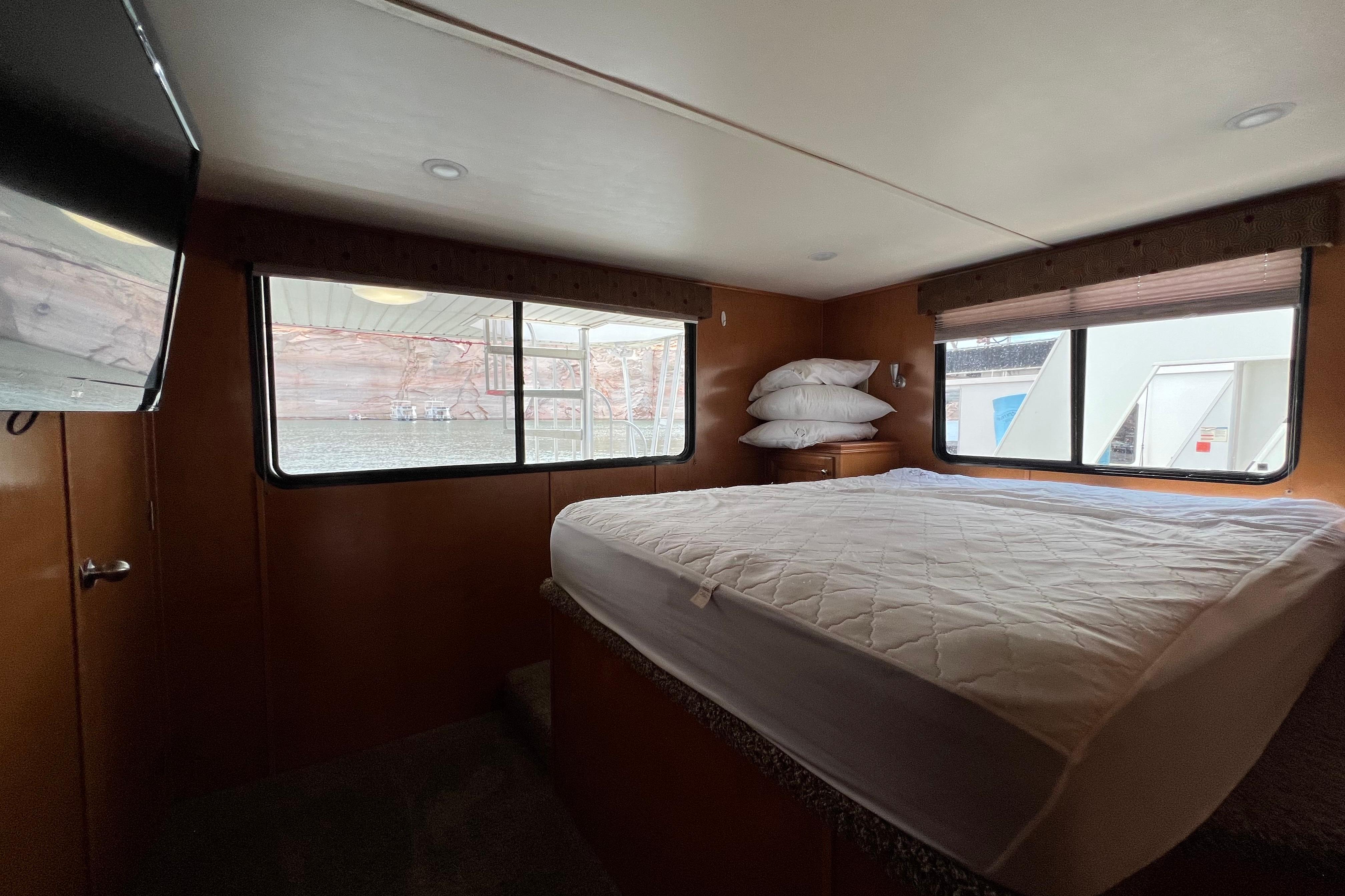 Cozy bedroom interior of 2013 Destination Yacht Lotta Yachta with large windows and comfortable bed.