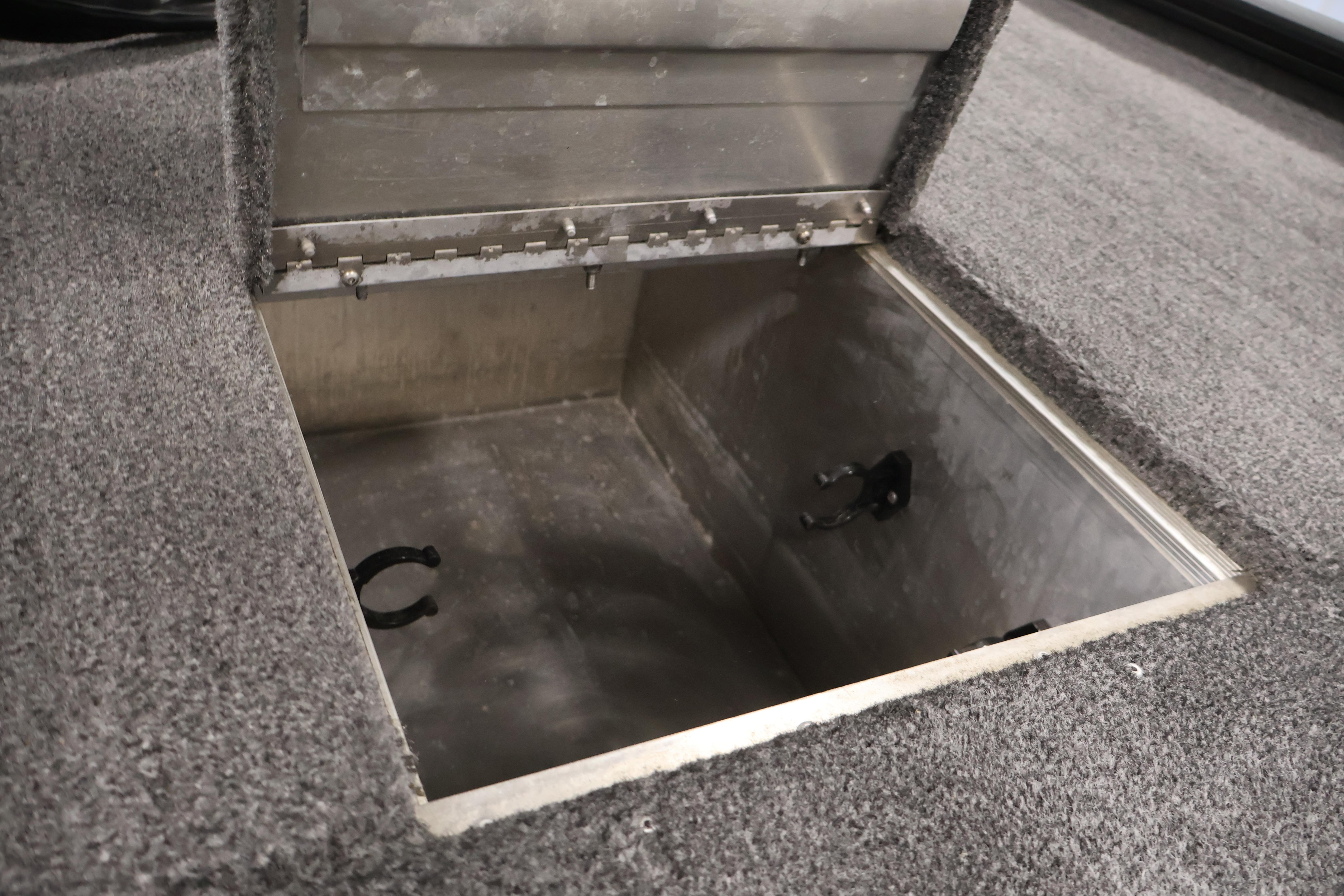 Open storage compartment in 2024 Tracker Pro 170 boat, featuring carpeted interior.