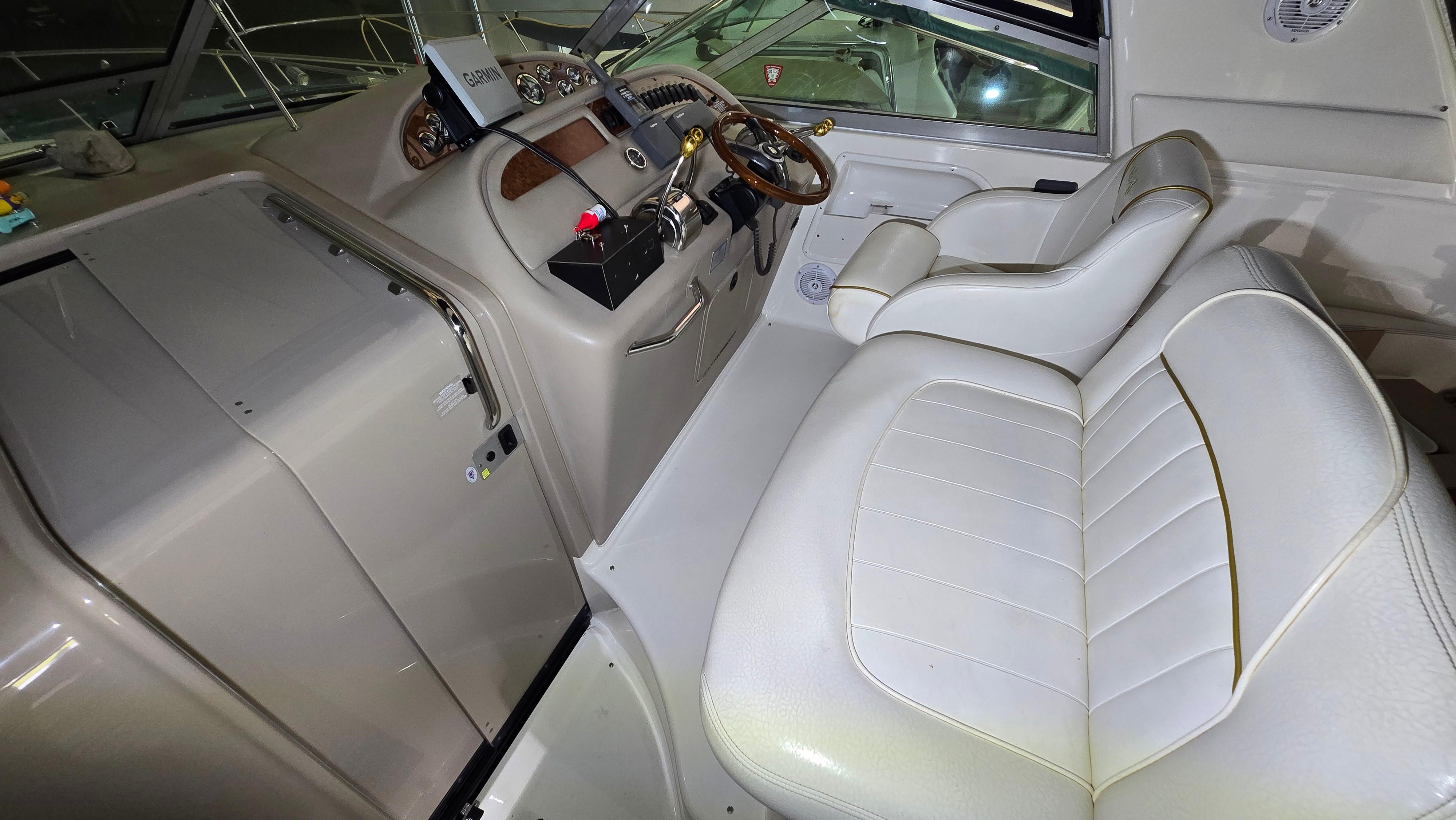 Cockpit of 2000 Sea Ray 310 Sundancer with white leather seating and control panel.