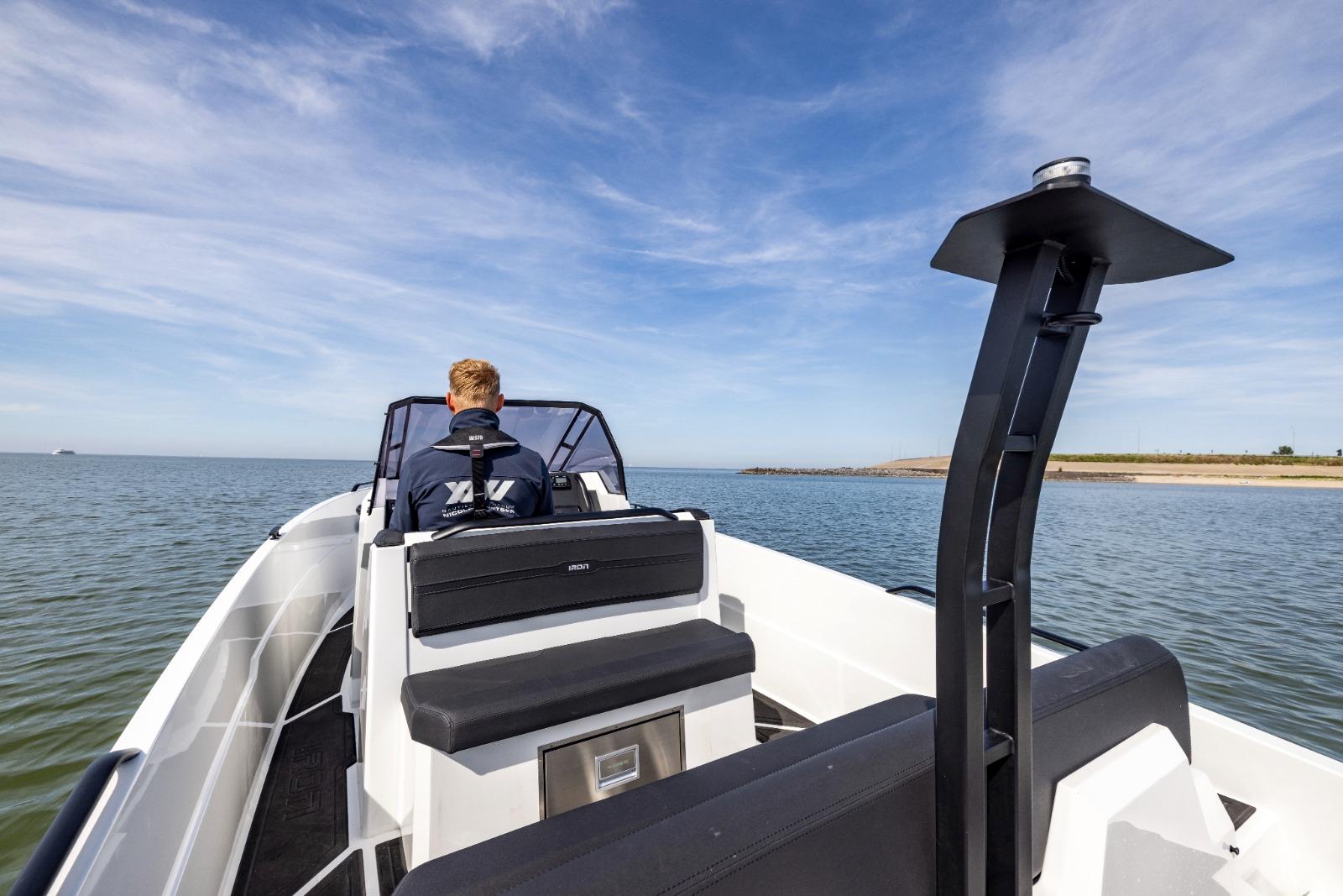 Person steering Iron 707 boat on open water, clear sky, 2022 model.