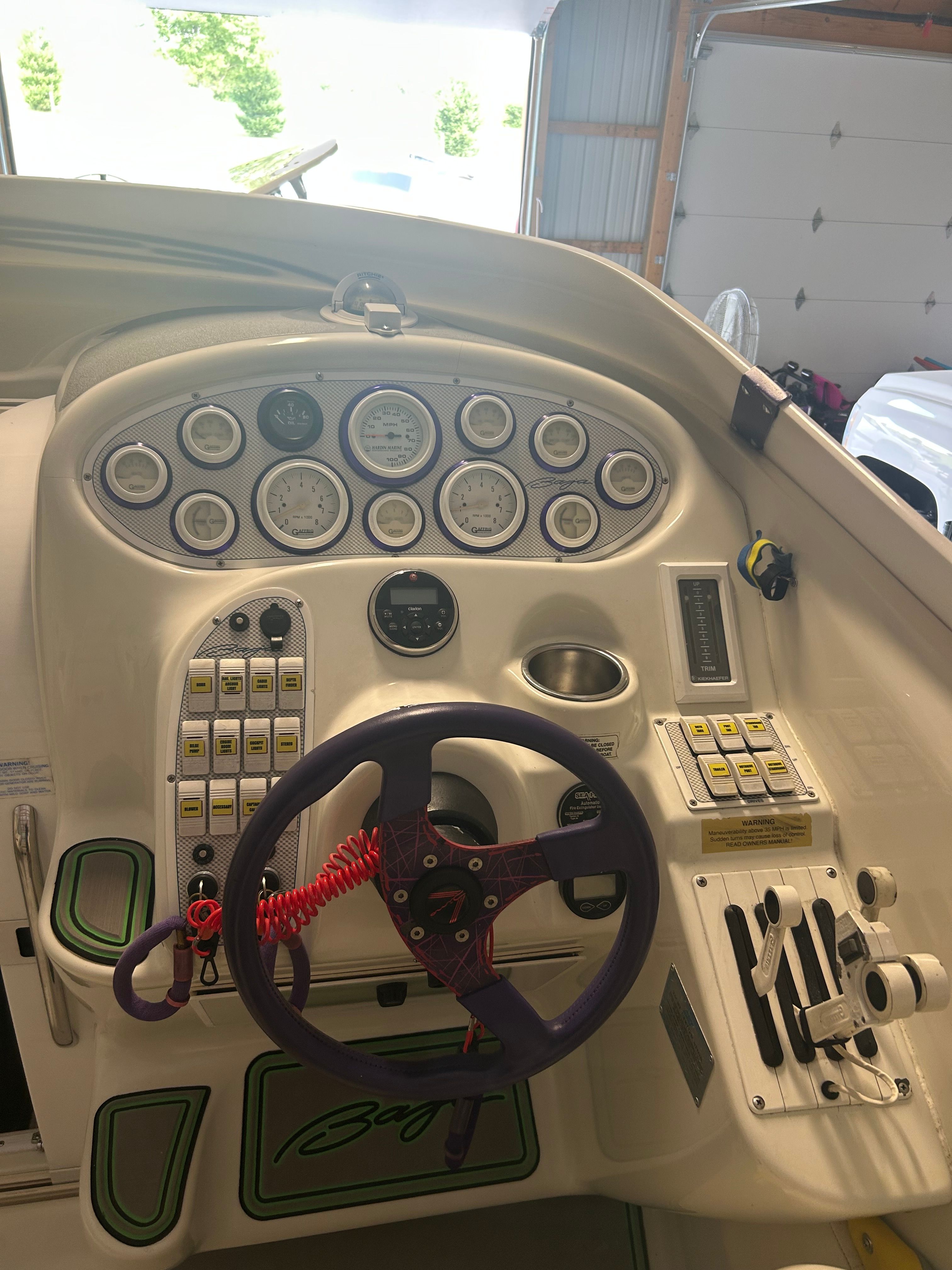The cockpit of a 1996 Baja 302 with a purple steering wheel and numerous gauges.