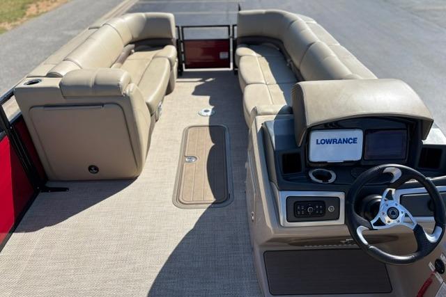 2025 Regency 250 DL3 pontoon boat interior with beige seating and steering console.