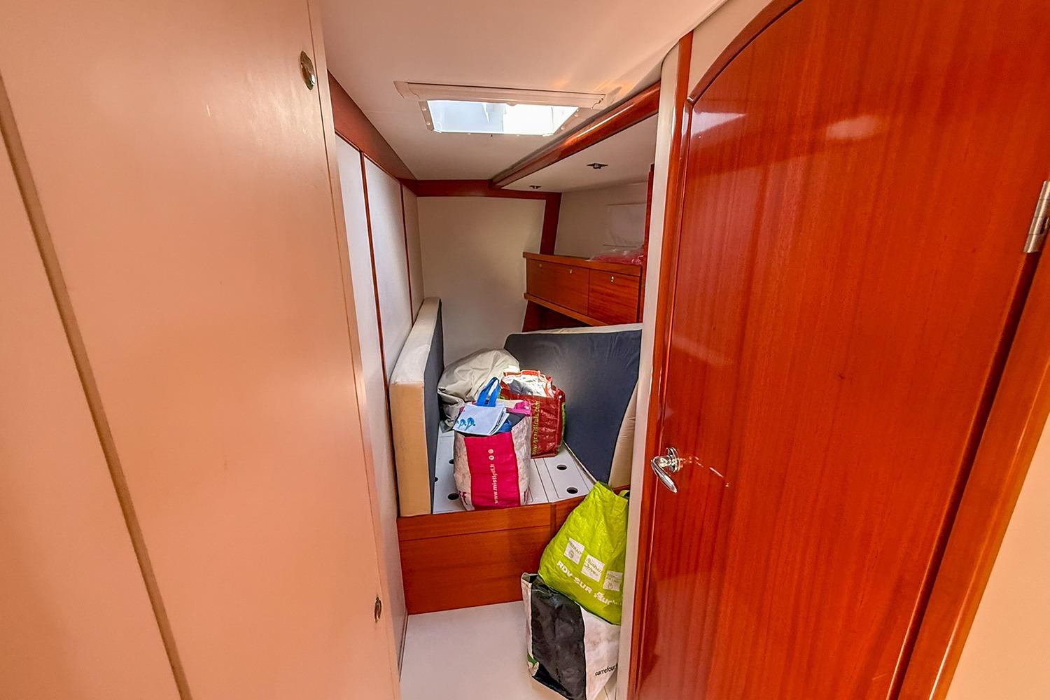 Interior cabin of 2004 Hanse 531 yacht with wooden finish and storage items.
