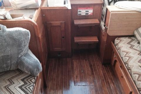 Interior of a 1980 Sloop 27.7 Bristol sailboat with wooden flooring and seating.