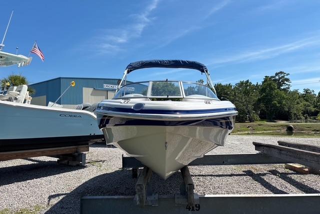 2012 Tahoe Q8 SSi boat on trailer, parked outdoors under clear blue sky.