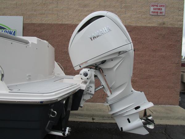 2025 Solara S-250 CW boat with Yamaha outboard motor, docked near a brick wall.