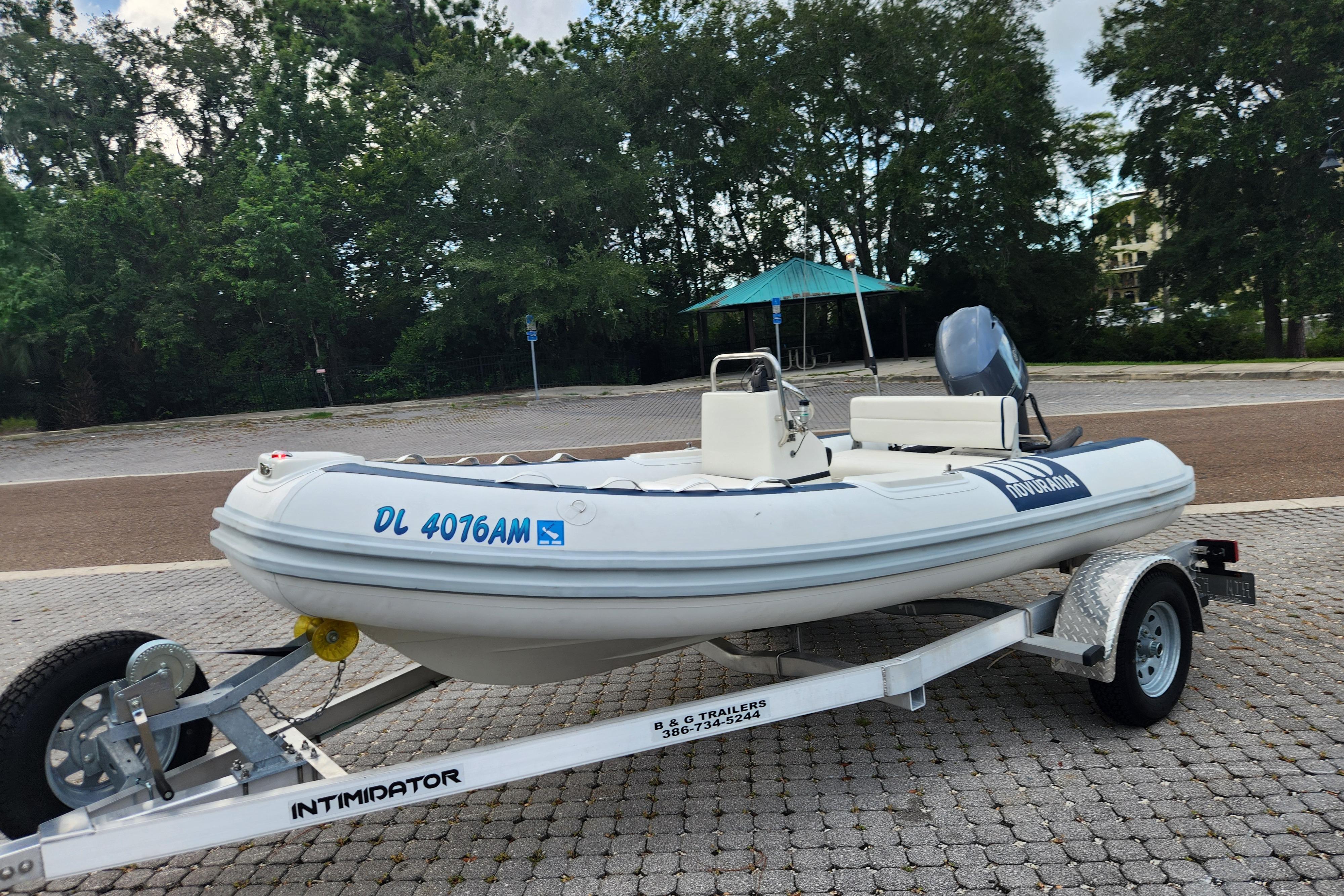 2019 Novurania DL 400 boat on trailer, parked outdoors with trees in background.