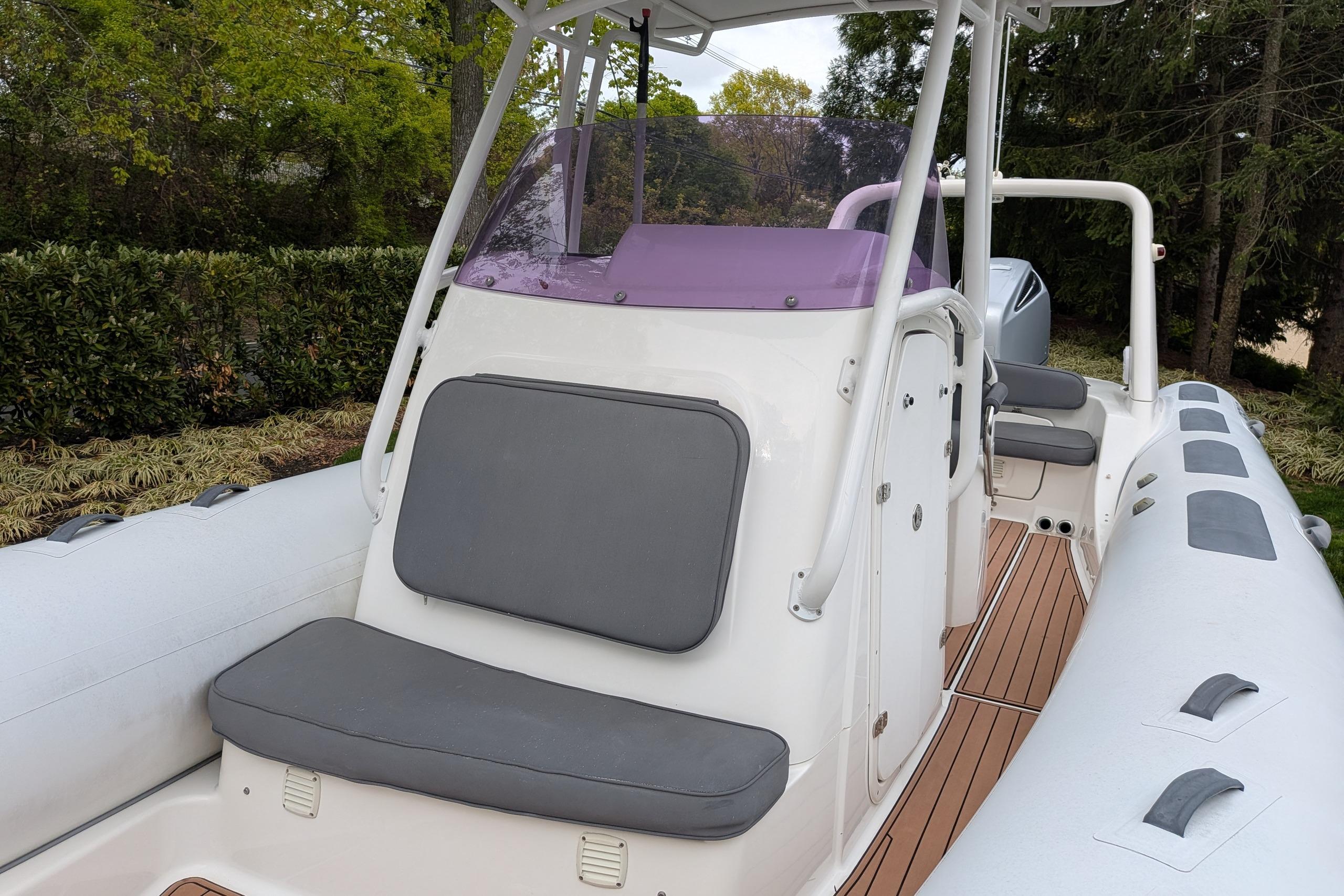 2016 Brig E780 boat with cushioned seating and sleek design in a wooded setting.