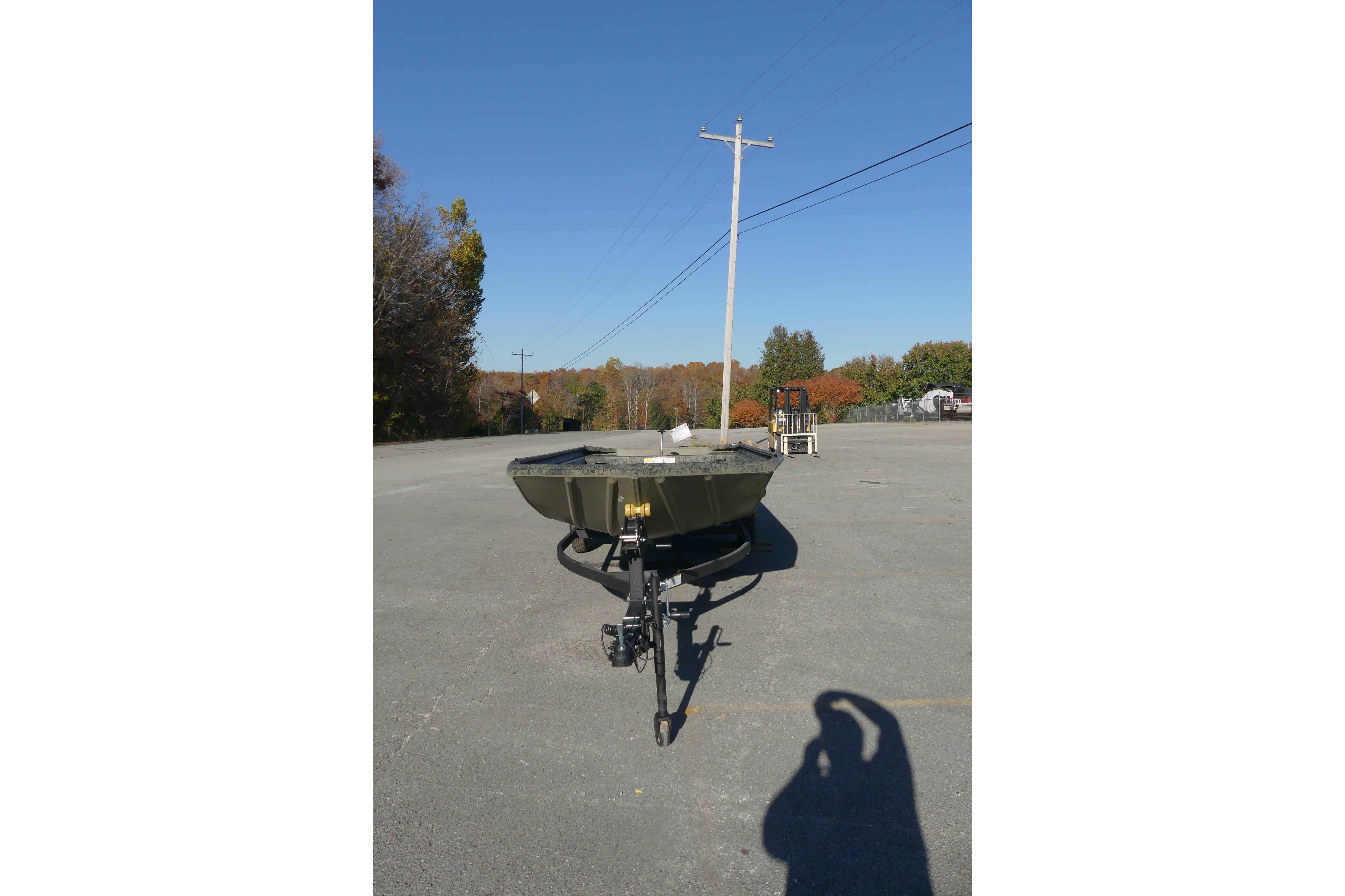 2026 Tracker Grizzly 1860 Utility boat on trailer in parking lot.