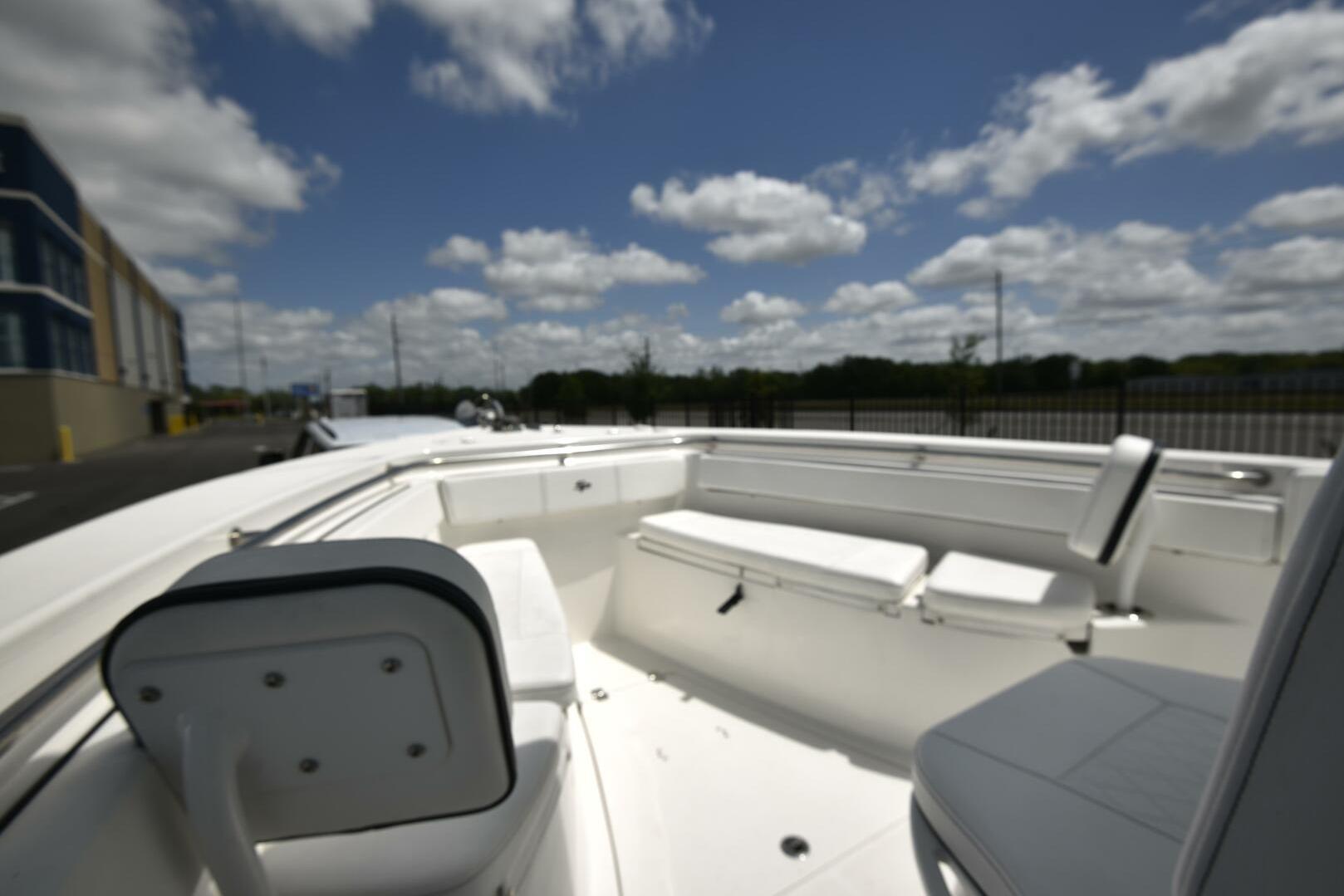 2023 Sea Pro 239 Deep V CC boat interior with seating, under a partly cloudy sky.