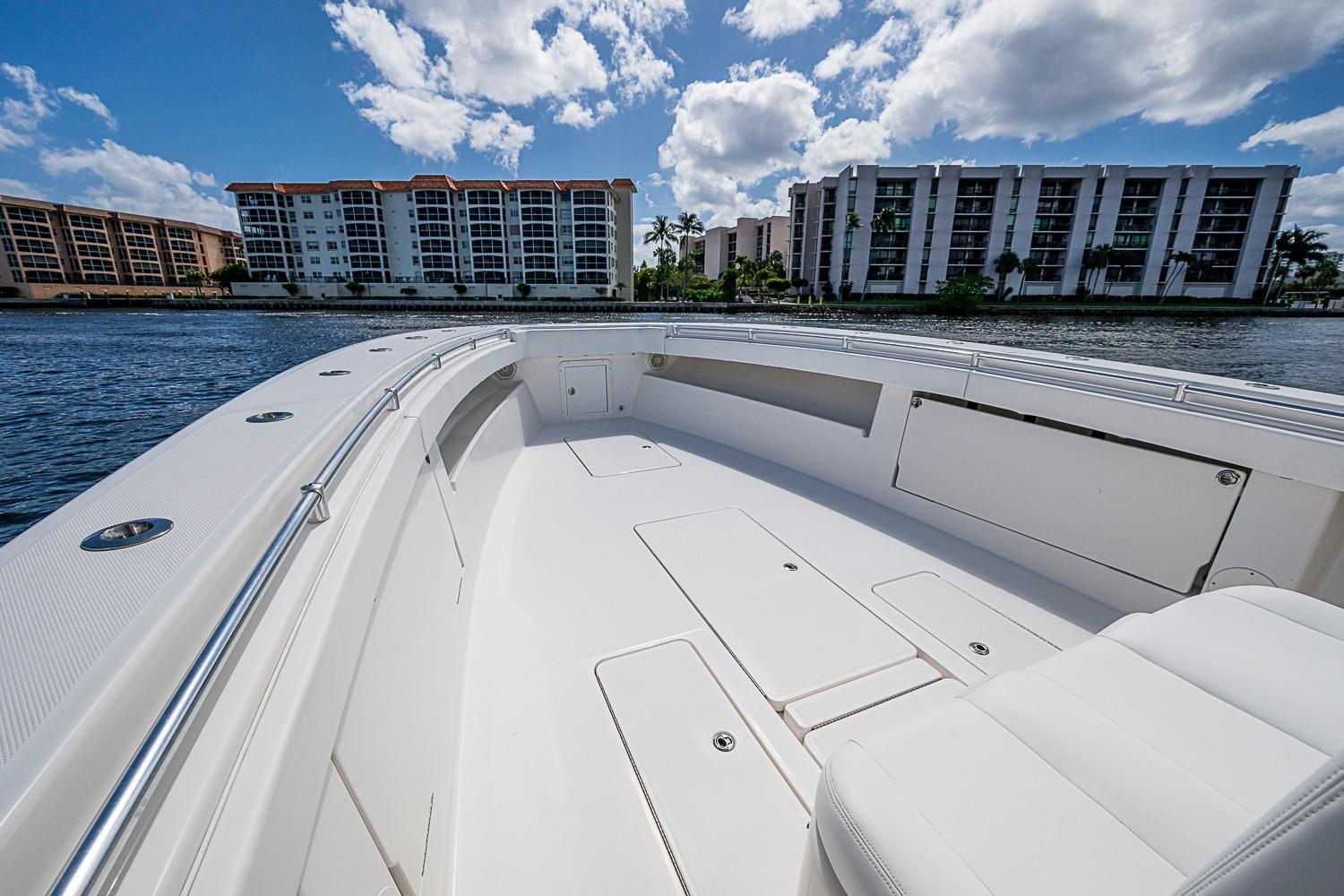 2015 Invincible 42 Open Fisherman boat on water, with modern buildings in background.