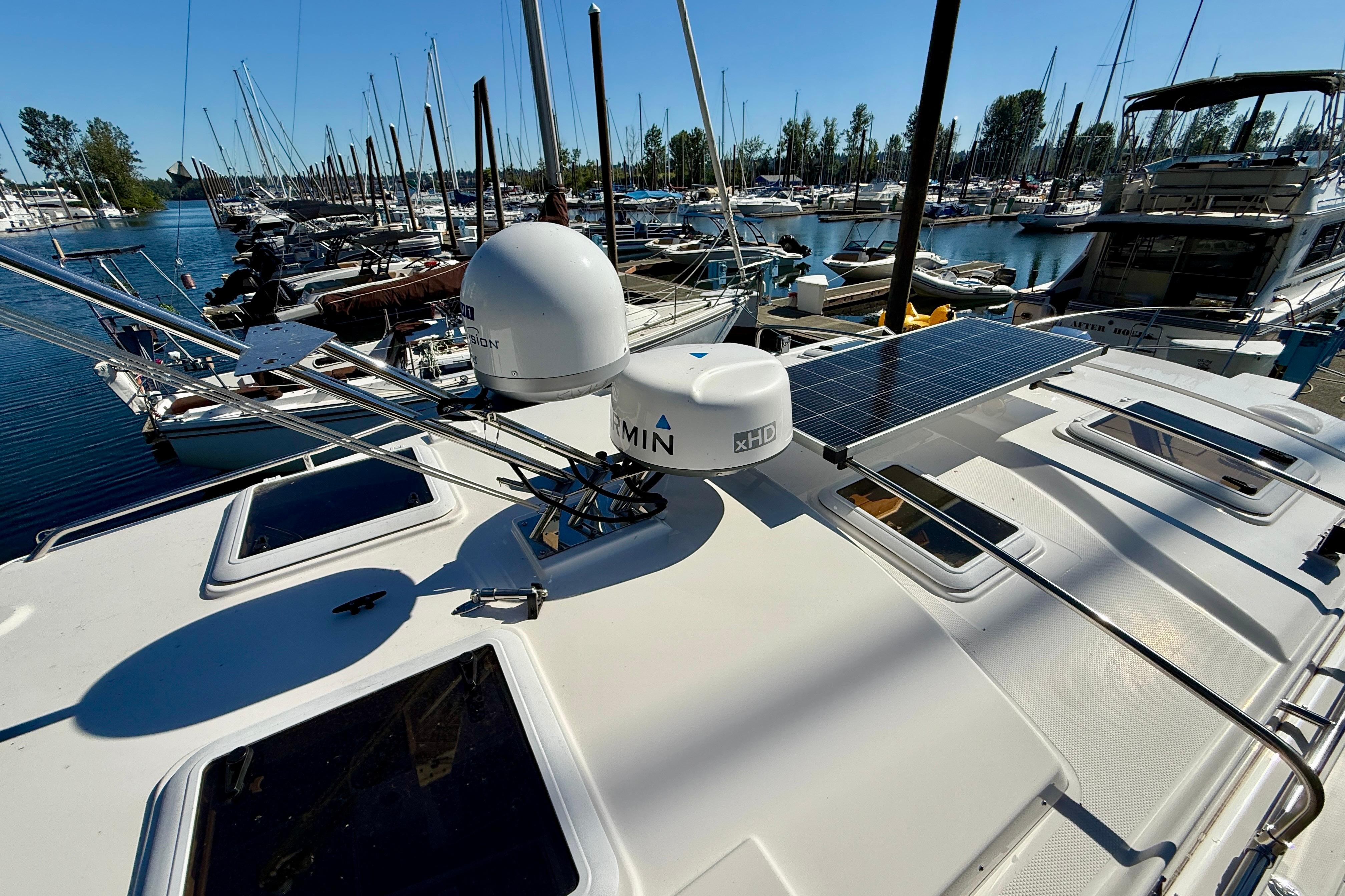 2023 Cutwater C-30 Sedan yacht with solar panels docked at a marina.