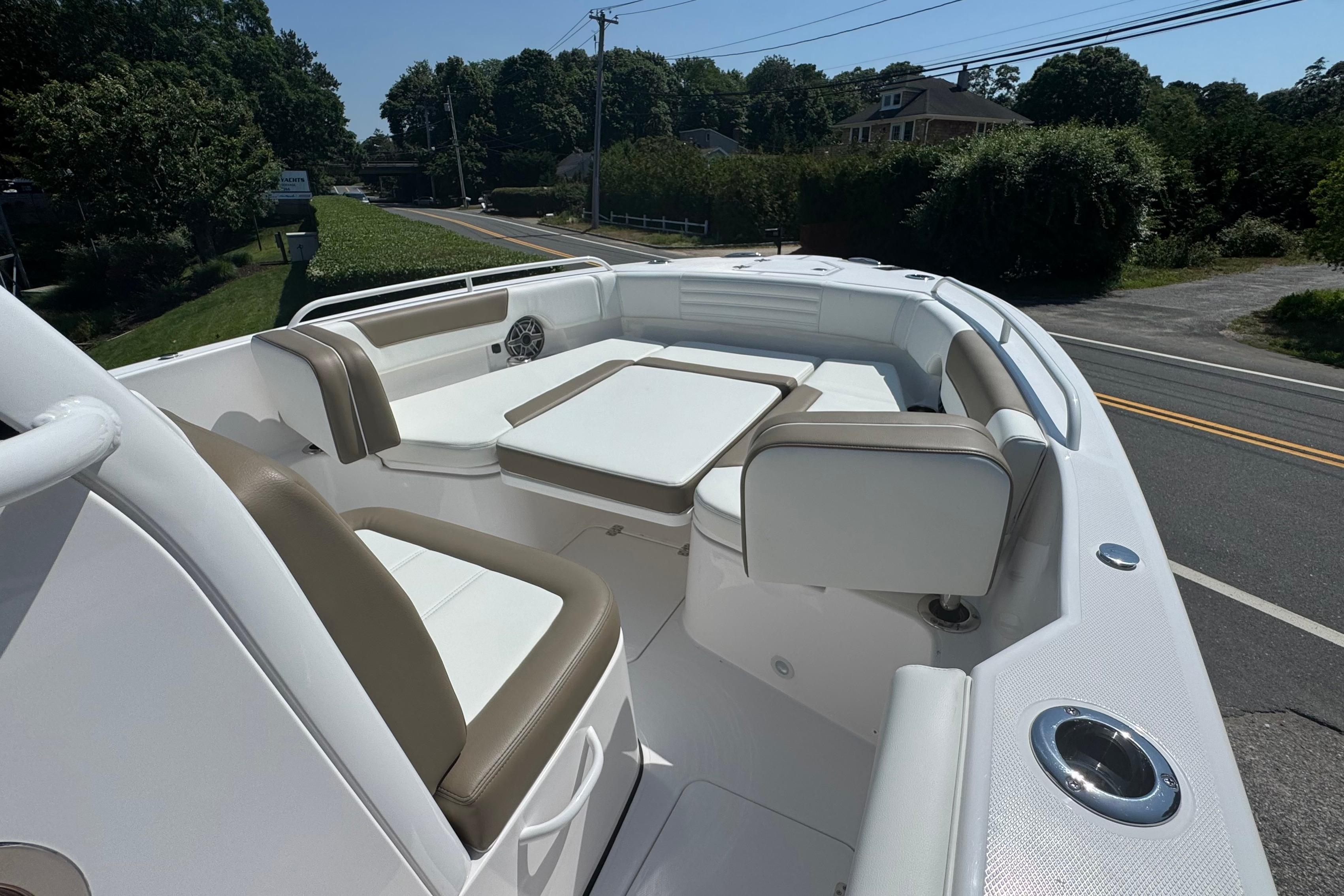 2026 Edgewater 250CC boat interior with white and tan seating, located near a road.