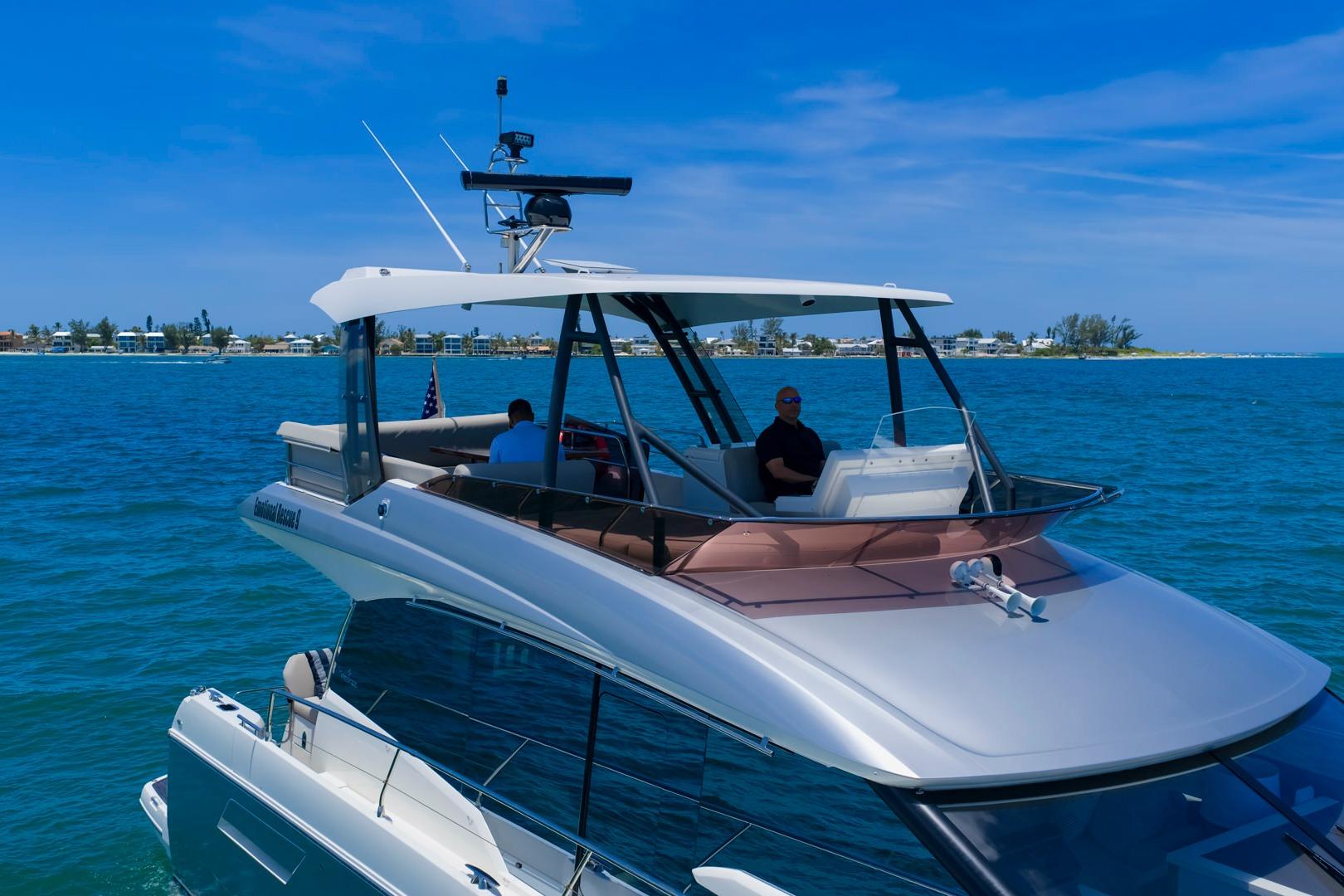 Luxury 2022 Prestige 520 yacht cruising on clear blue waters under a sunny sky.