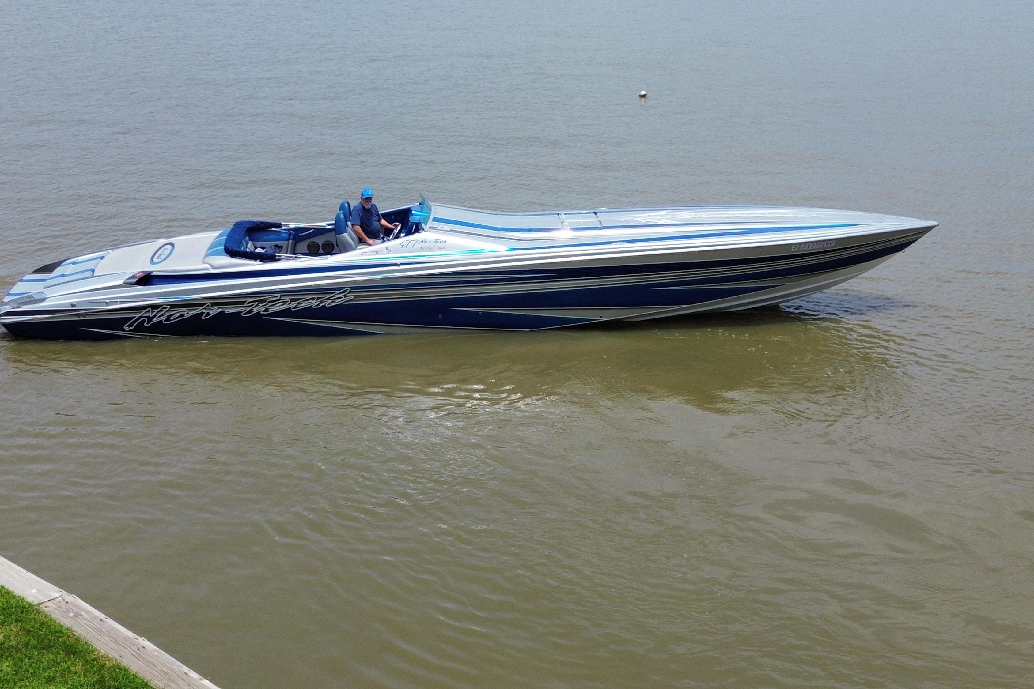 2013 Nor-Tech 477 SPX Vee Bottom speedboat on calm water, featuring sleek blue and silver design.