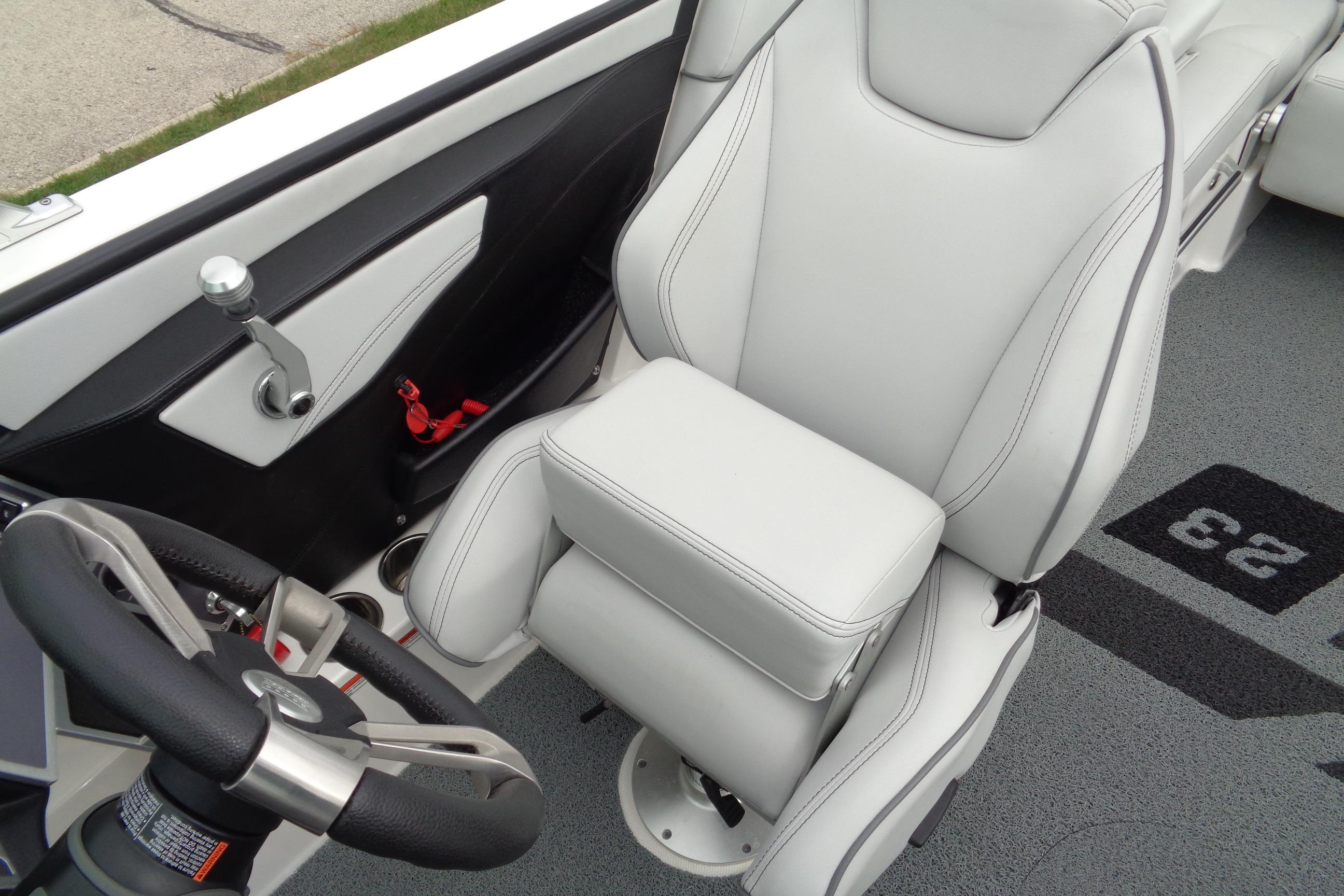 2020 MasterCraft XT23 boat interior with sleek white captain's seat and steering wheel.