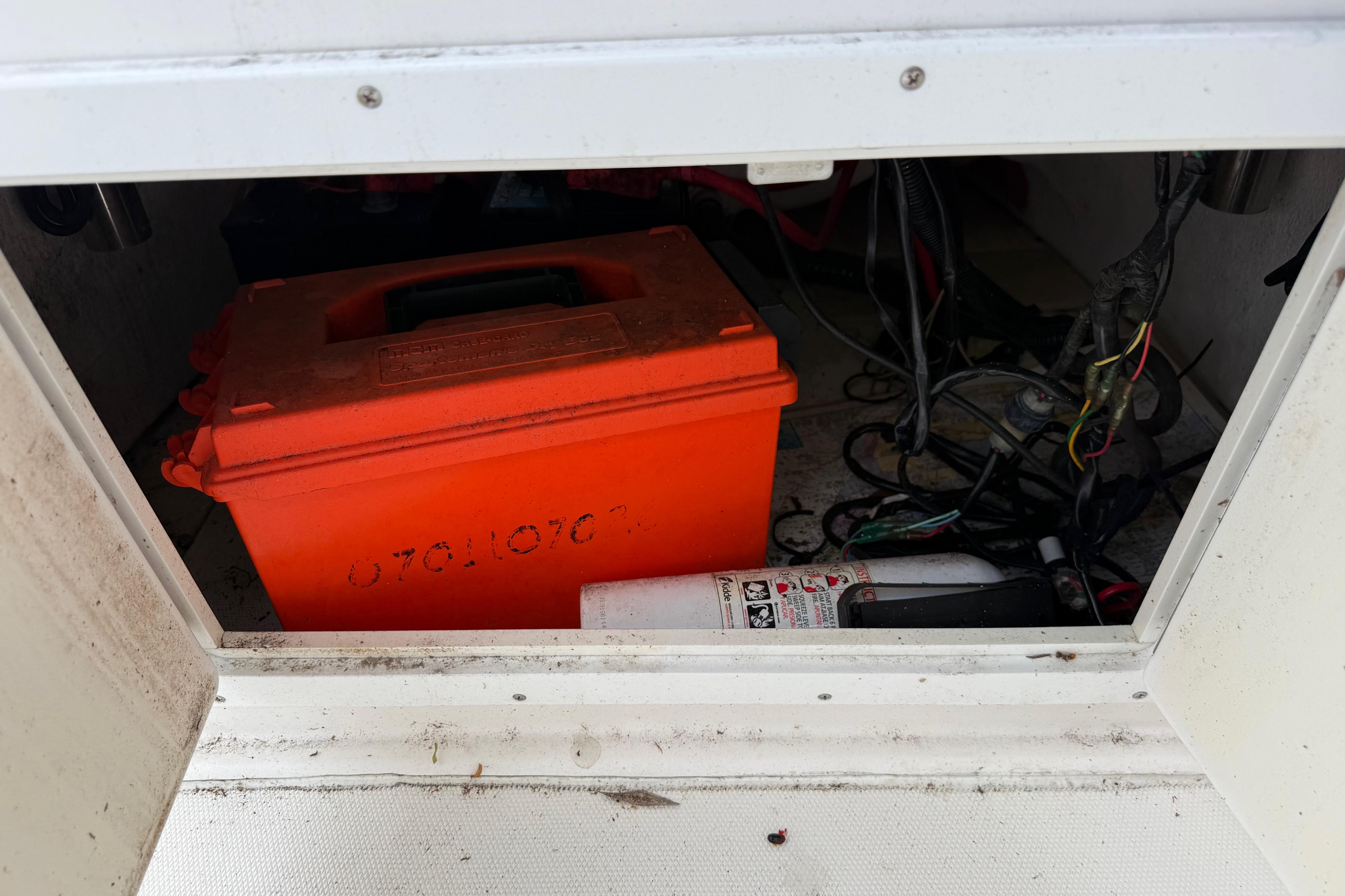 Storage compartment of a 2012 Clearwater 2000 Center Console with orange box and wiring.