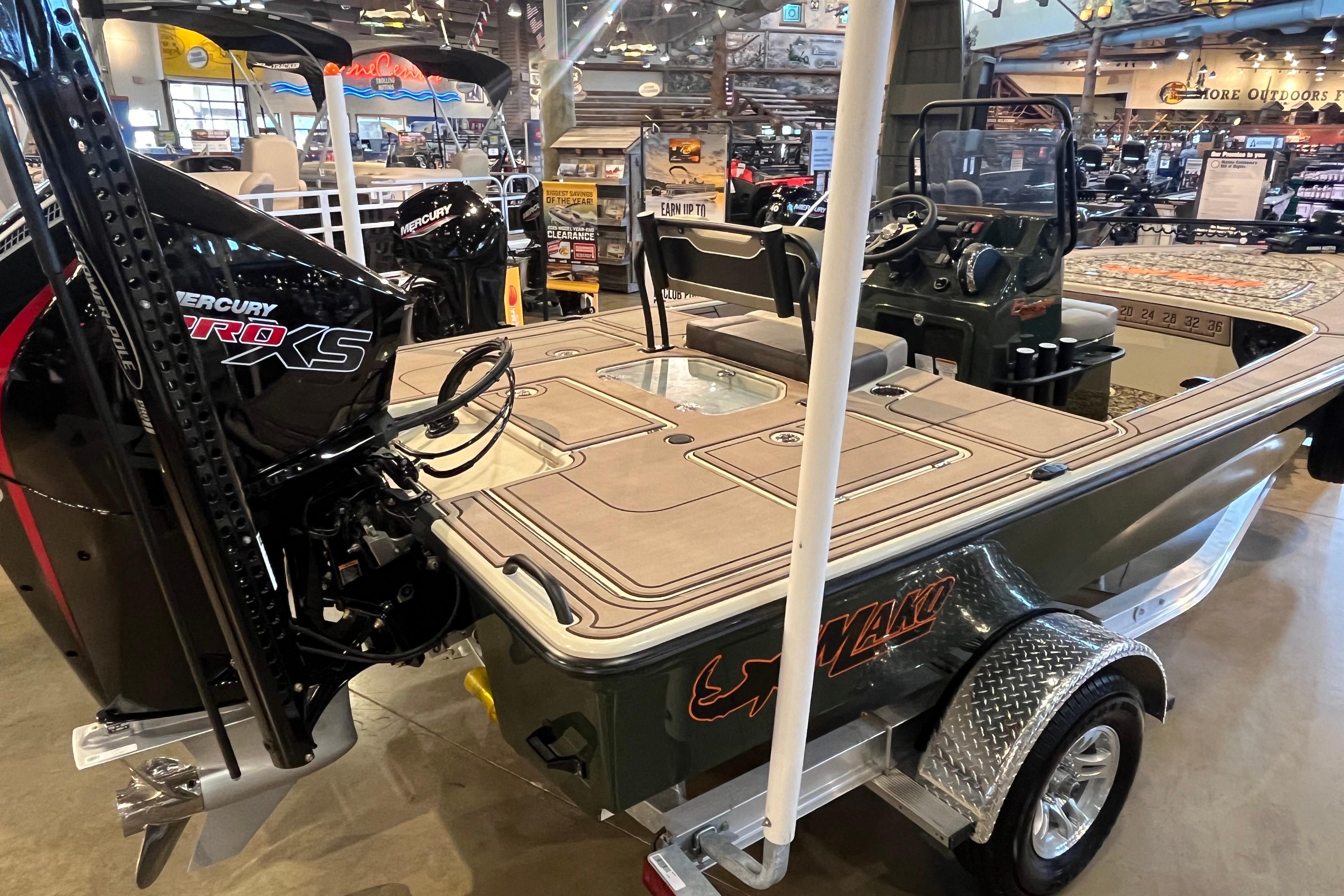 2025 Mako 18 Pro Skiff Backwater Edition boat displayed in showroom with Mercury Pro XS engine.