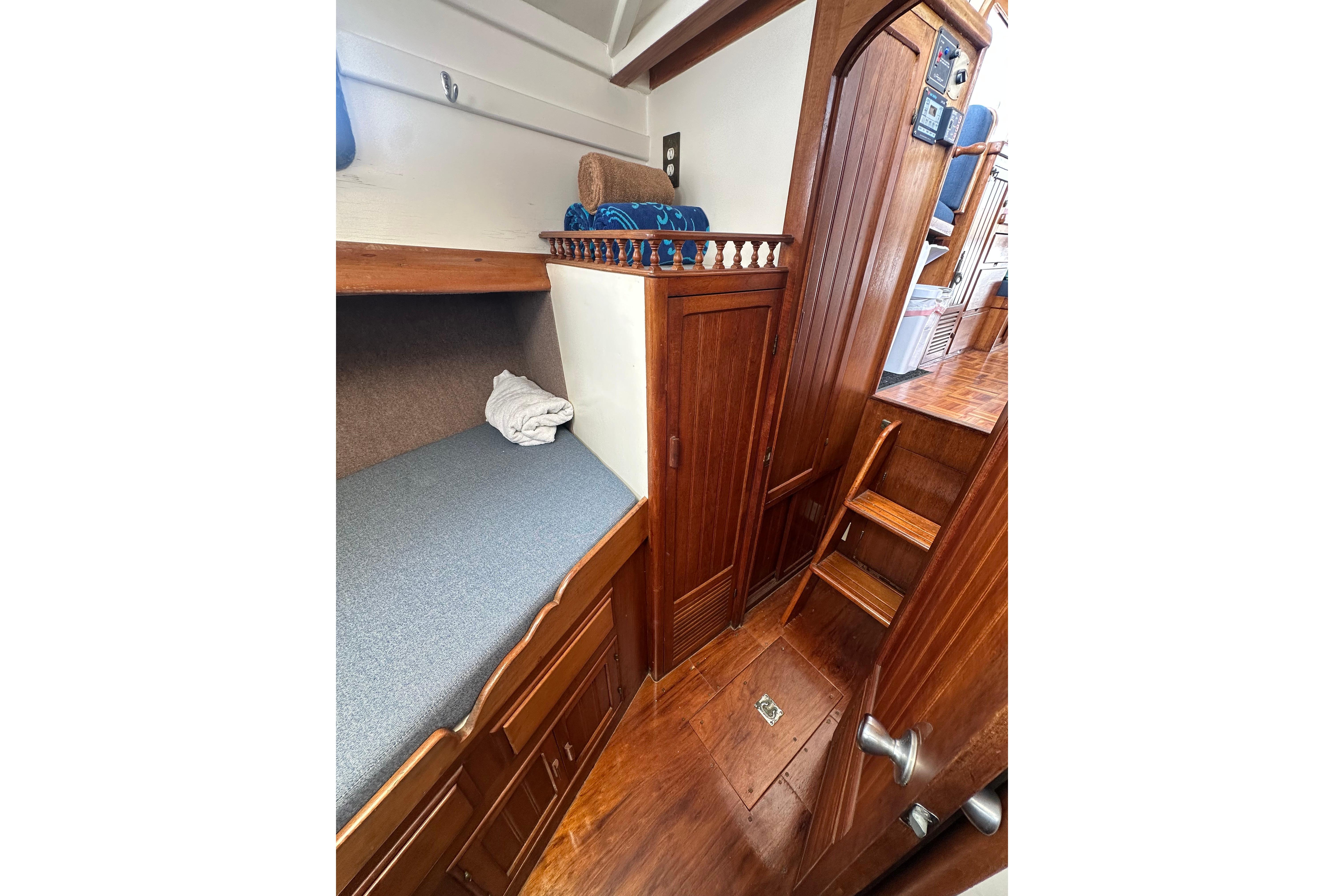 1973 CHB 33 boat interior with wooden cabinetry, bunk bed, and stairs.