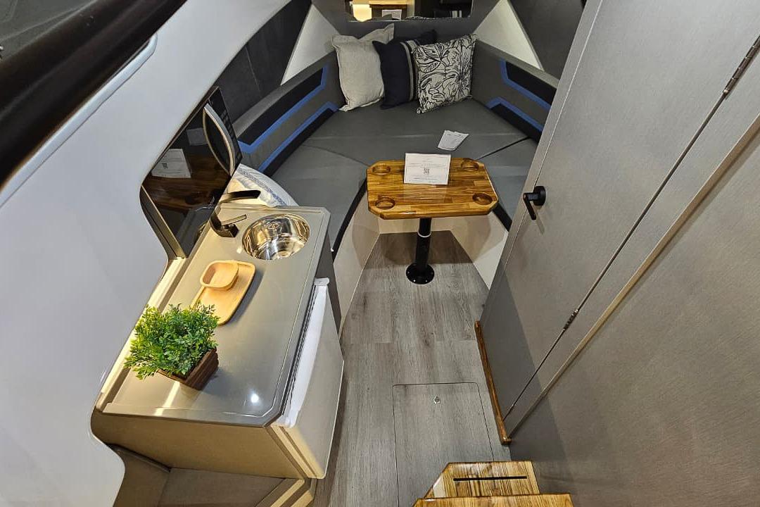 Modern interior of 2026 Hanover 327 boat with kitchenette and seating area.