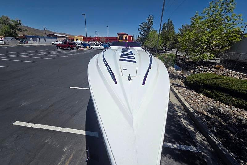 2004 Fountain 38 Lightning boat parked in a lot, showcasing sleek design and aerodynamic features.