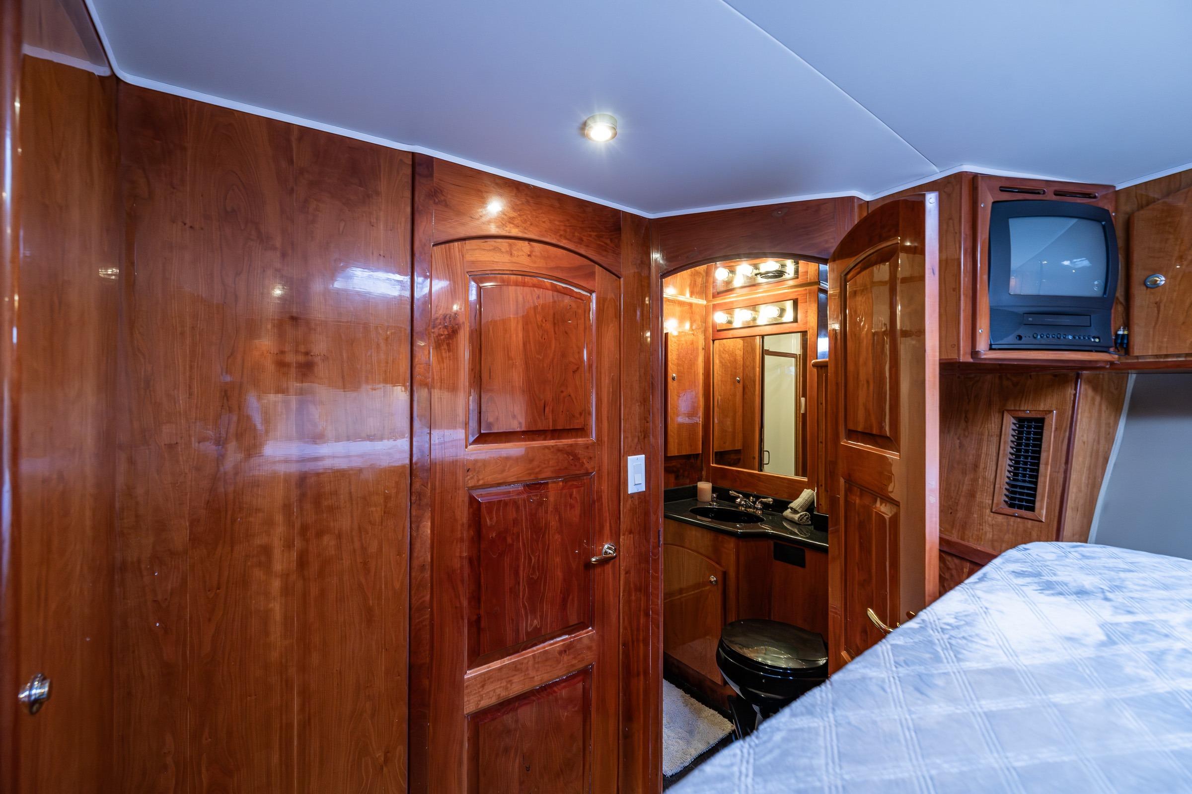 Luxurious 2001 Navigator Pilothouse yacht interior with wood paneling and compact bathroom.