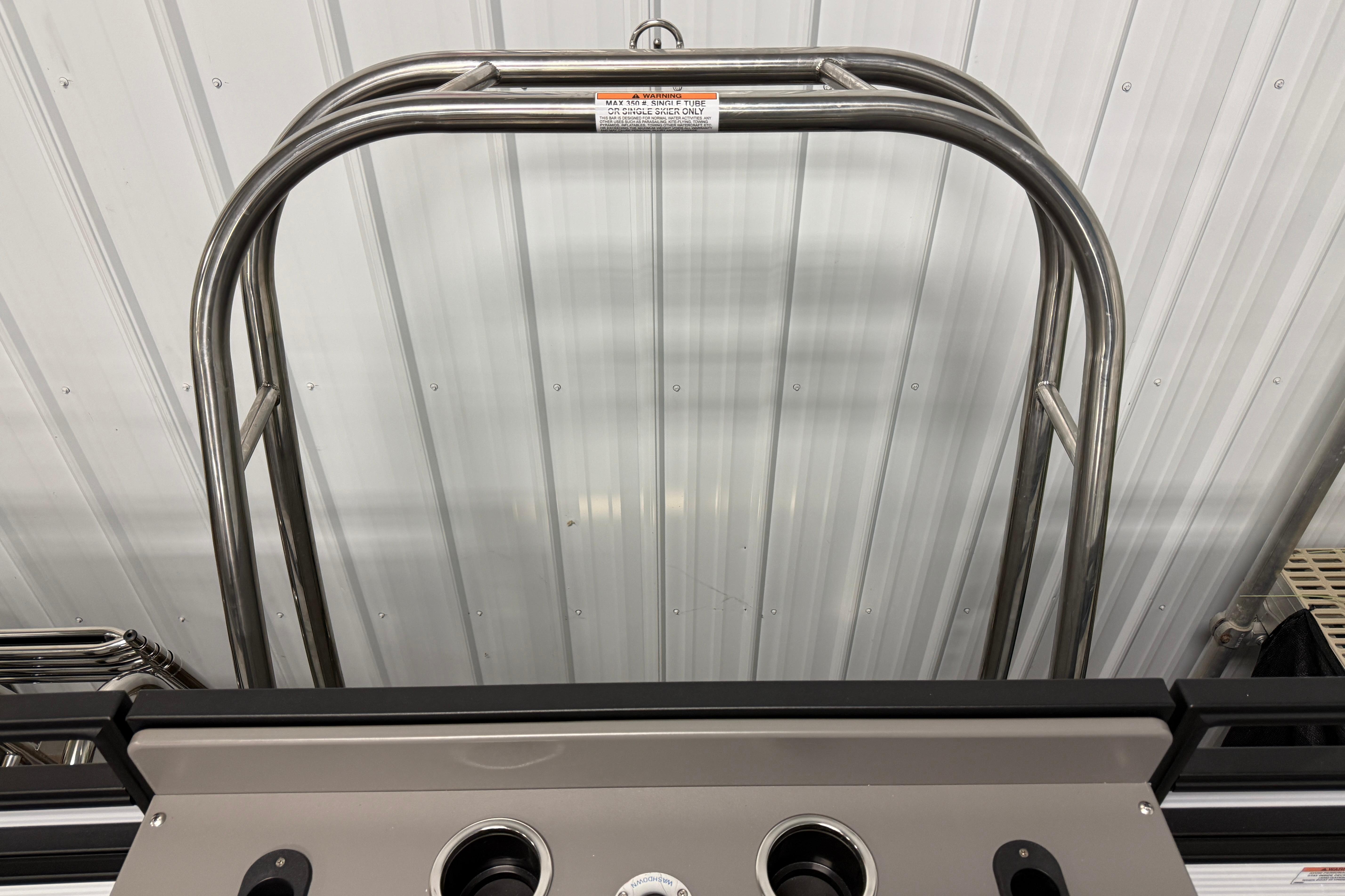 Stainless steel frame of 2026 Qwest M-Class 22 Pro Sport boat against metal wall.