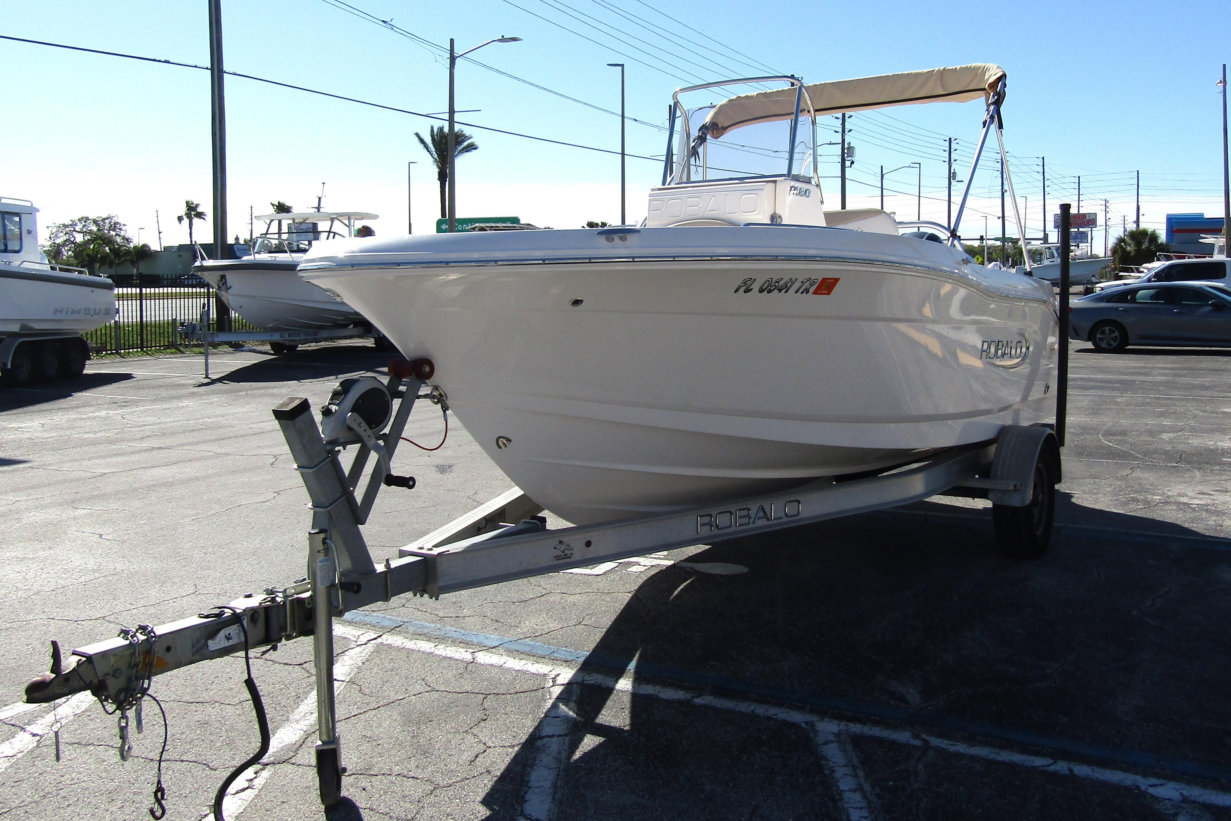 2019 Robalo R180 Center Console boat on trailer in parking lot.