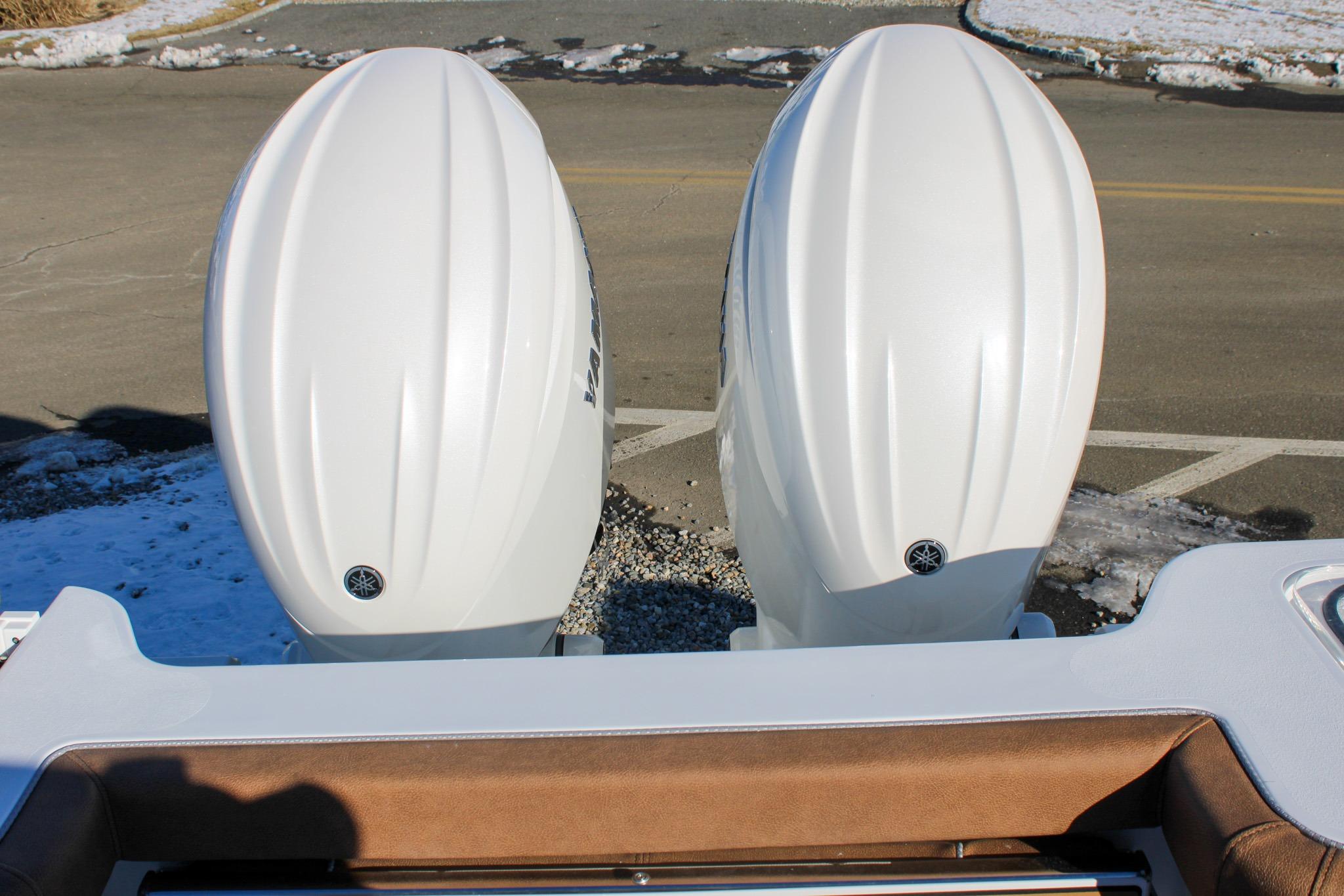 Twin outboard engines on a 2026 Sea Hunt Gamefish 25 boat, parked on a snowy day.