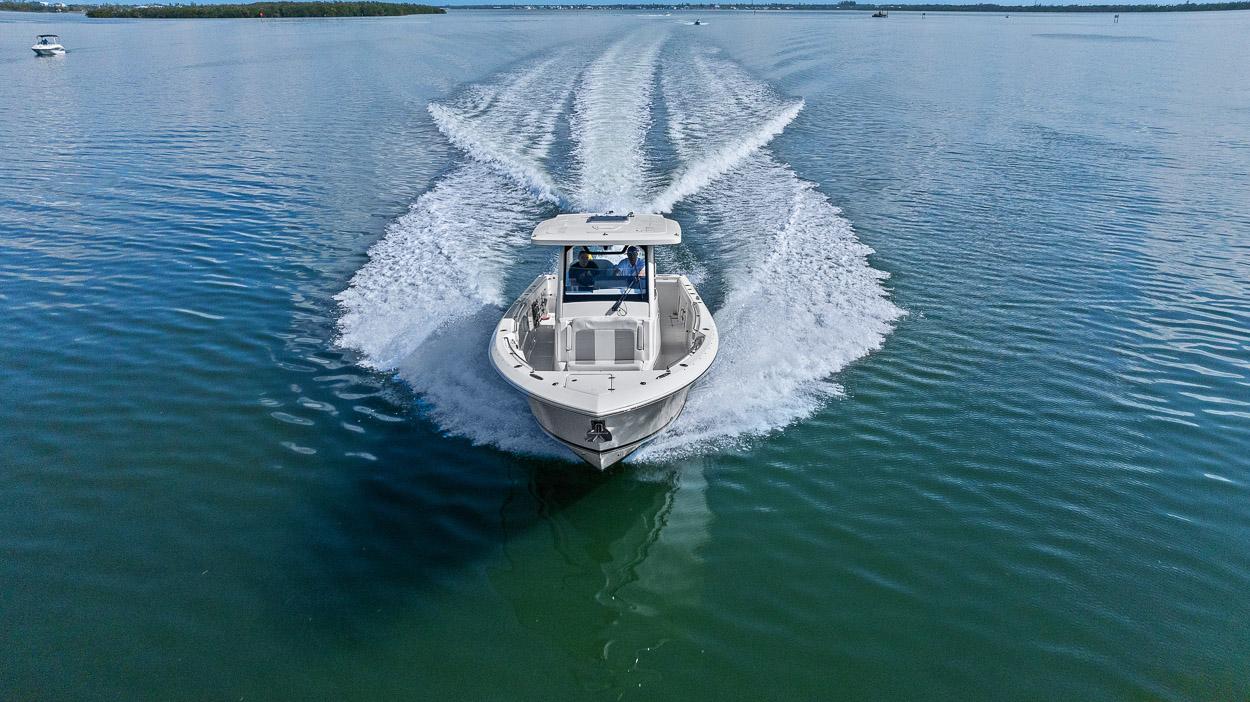 2021 Pursuit S 328 Sport boat cruising on calm water, leaving a wake behind.