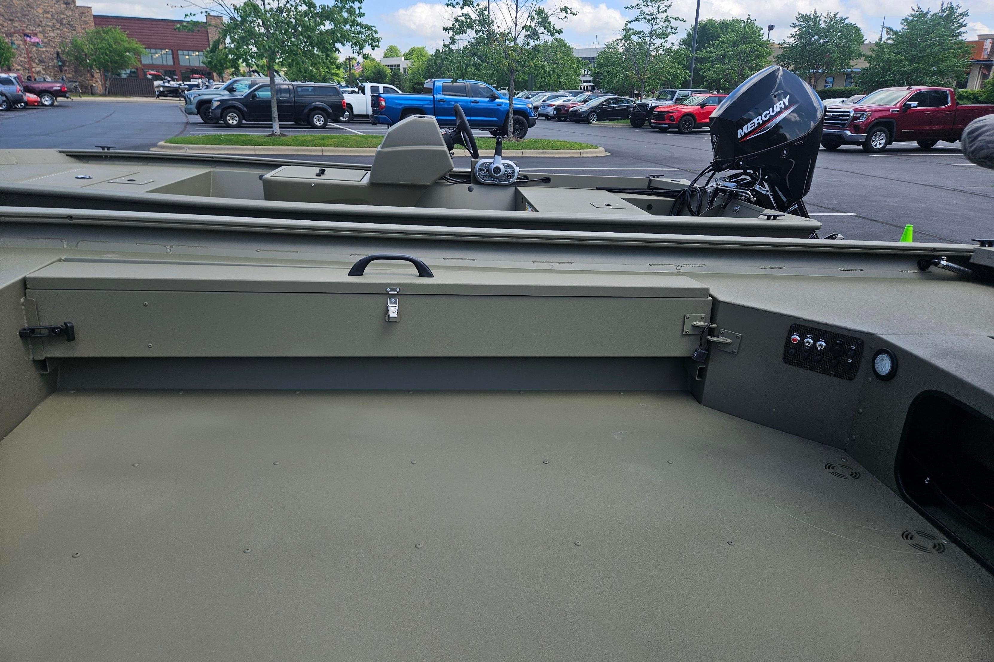 2026 Tracker Grizzly 1654 T Sportsman boat interior with Mercury outboard motor in parking lot.