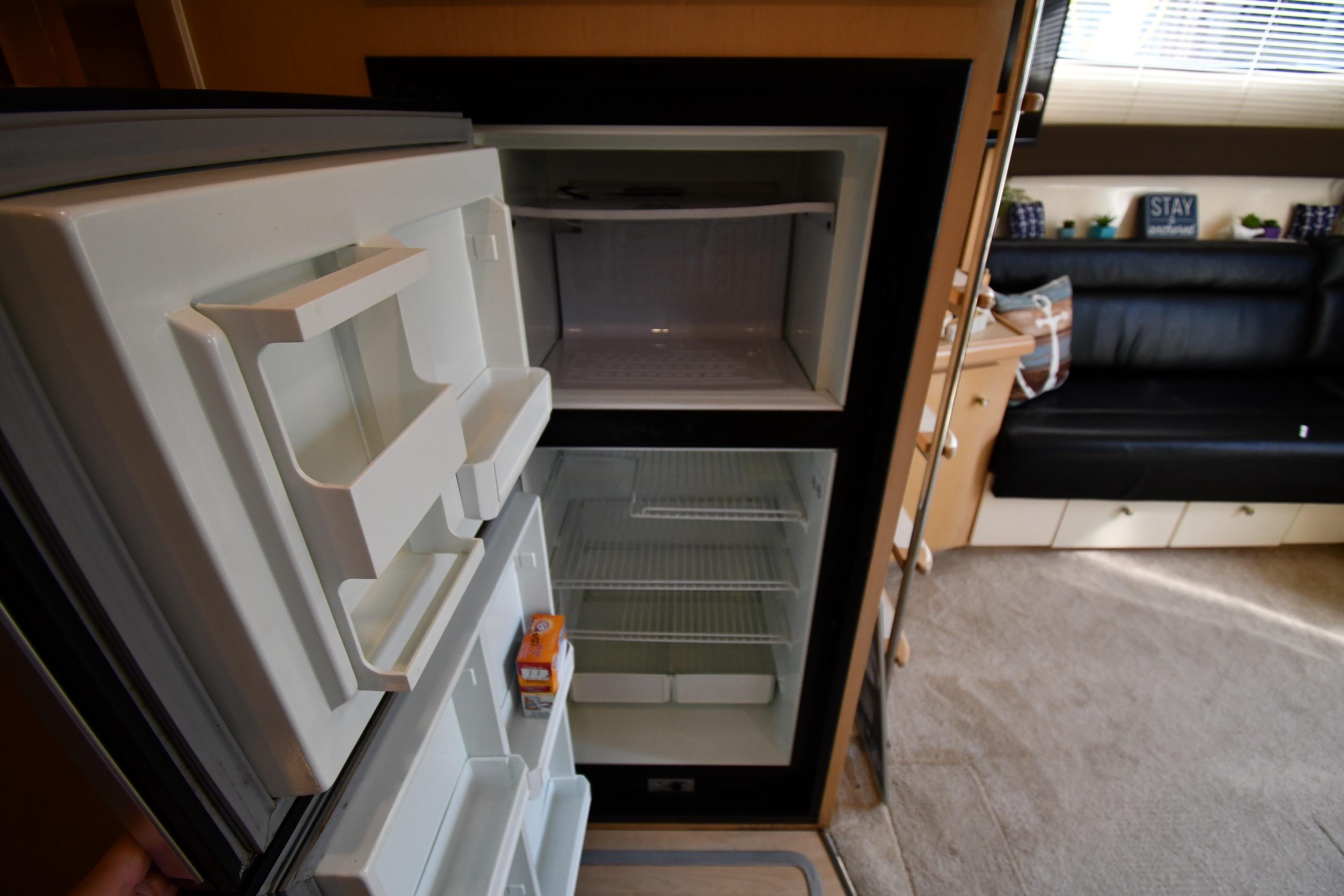Interior of a 2000 Carver 350 Mariner showing an open refrigerator in the cabin.