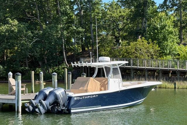 2014 Southport 29 FE boat docked by a wooded shoreline.